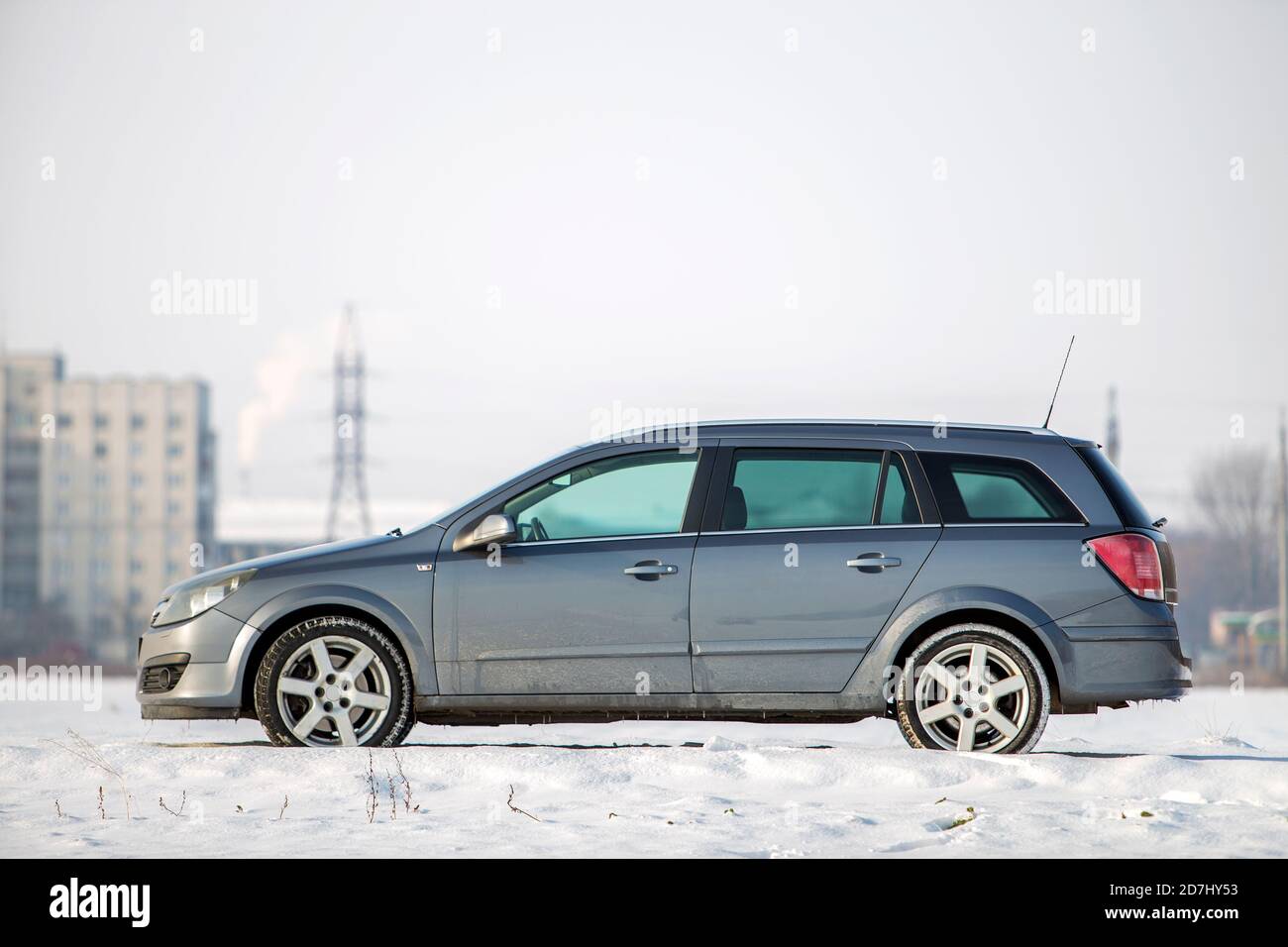 Voiture garée dans champ neigeux sur journée d'hiver. Banque D'Images