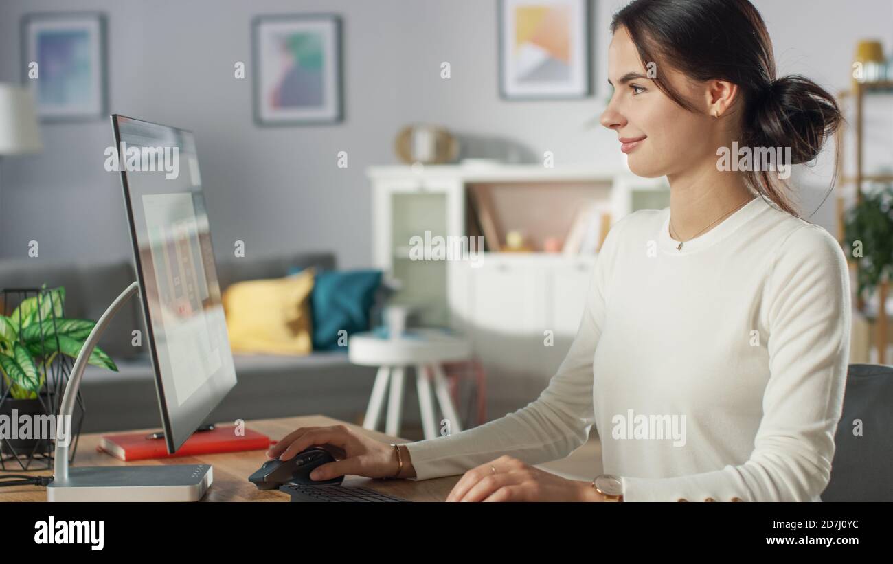 Portrait de la belle jeune femme travaillant sur la conception d'applications mobiles sur son ordinateur personnel à la maison. Banque D'Images