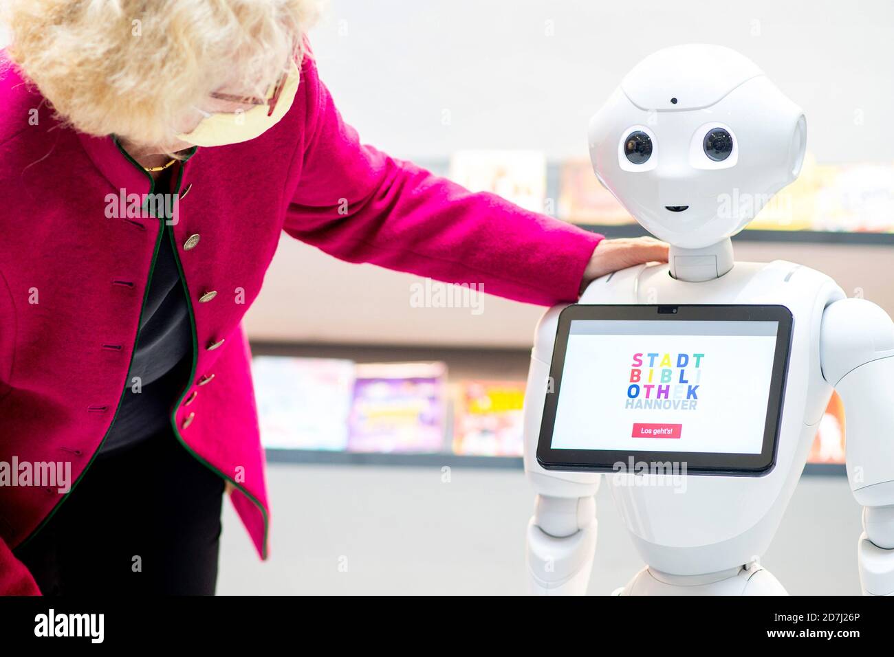 Hanovre, Allemagne. 23 octobre 2020. Carola Schelle-Wolff, directrice de la bibliothèque publique de Hanovre, communique dans la bibliothèque publique centrale de Südstadt avec un robot humanoïde, qui servira à l'avenir d'orientation pour les visiteurs et répondra aux questions sur l'utilisation de la bibliothèque. Peu avant la Journée des bibliothèques, samedi (24.10.20), les bibliothèques du nord regardent en arrière sur une période difficile de six mois avec le virus corona. Credit: Hauke-Christian Dittrich/dpa/Alay Live News Banque D'Images