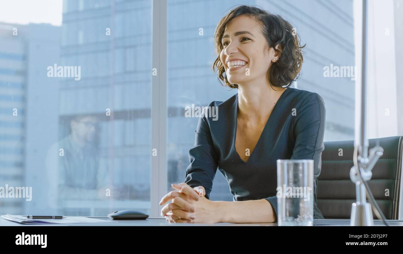 Portrait d'une jeune femme d'affaires béatiful souriant avec charme à son partenaire d'affaires potentiel. Femme indépendante forte en situation d'affaires. Banque D'Images