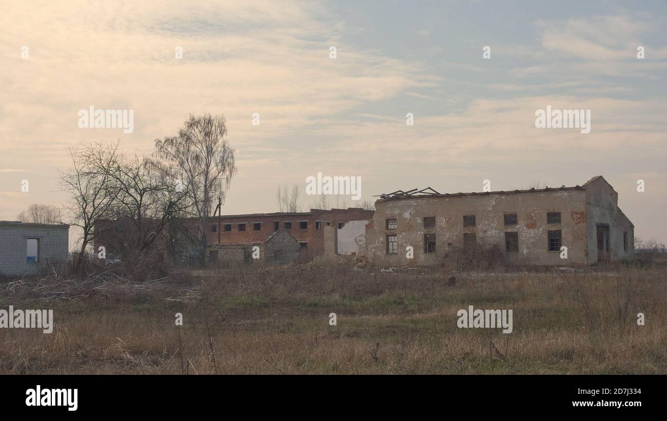 Un bâtiment industriel abandonné dans une entreprise agricole en Ukraine. Paysage du soir. Banque D'Images