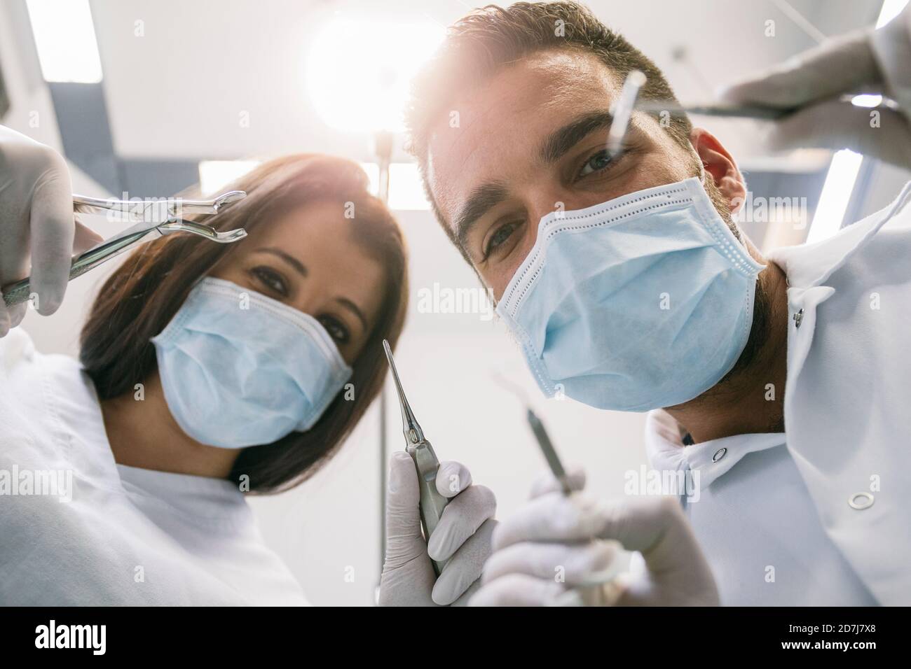 Dentiste et assistante féminine avec instruments médicaux pendant le traitement en clinique Banque D'Images