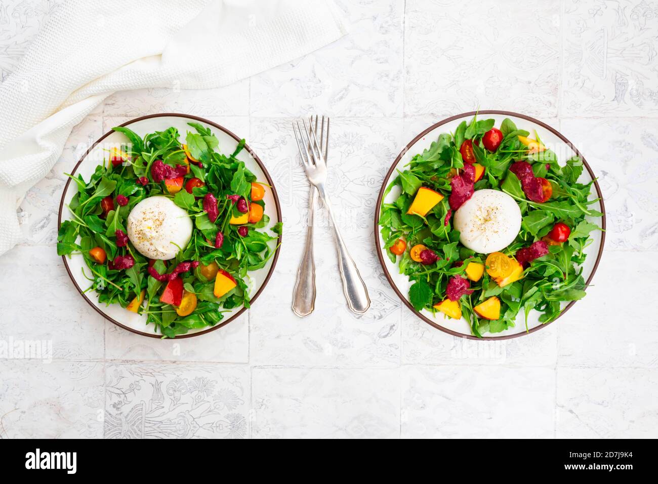 Deux assiettes de salade végétarienne avec fruits, légumes et fromage burrata Banque D'Images