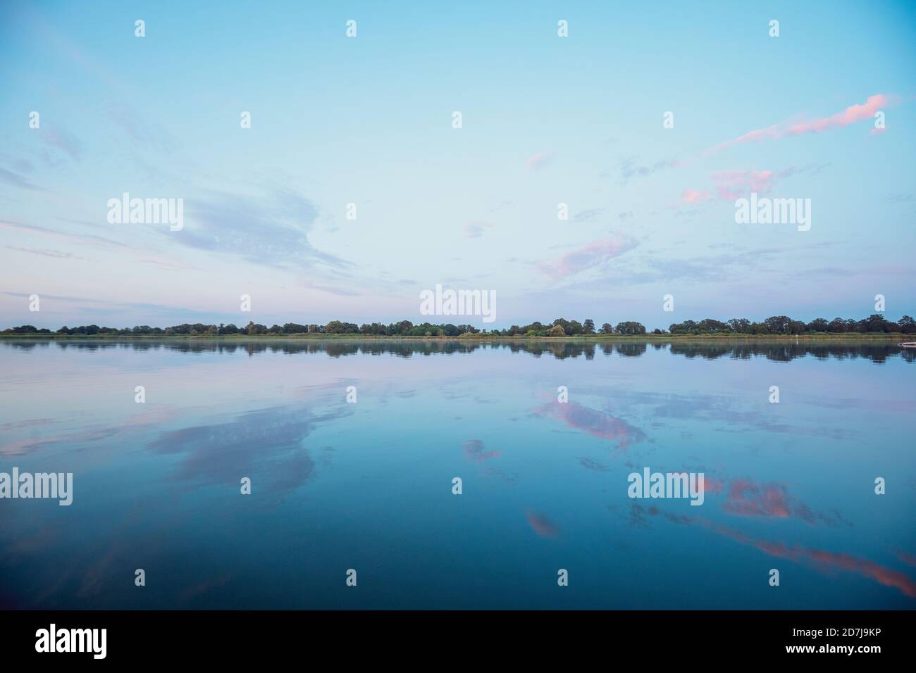 Les nuages réfléchissent dans l'eau au coucher du soleil Banque D'Images