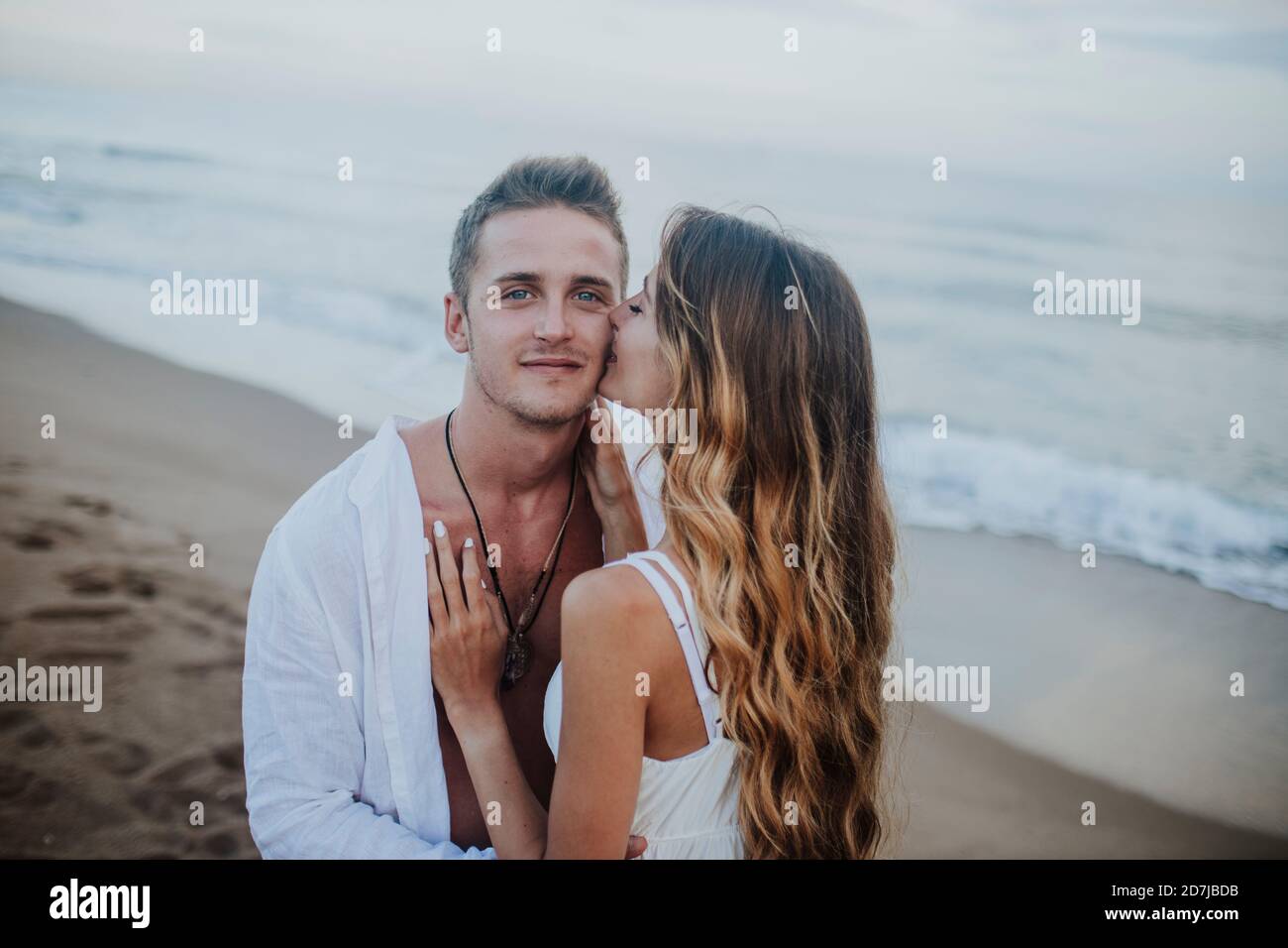 Jeune femme embrassant l'homme en se tenant à la plage Banque D'Images