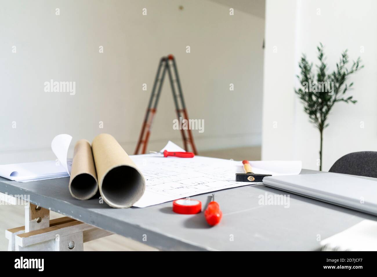 Des plans roulés couchés sur le bureau dans le studio d'architectes Banque D'Images