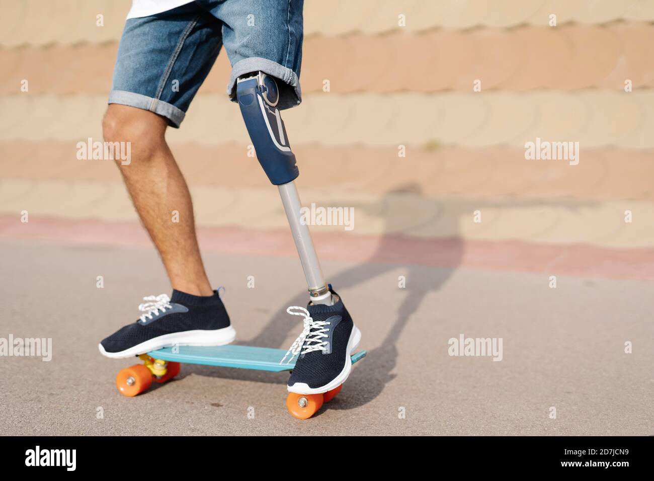 Athlète avec un membre et un pied artificiels debout sur un skateboard à cour Banque D'Images