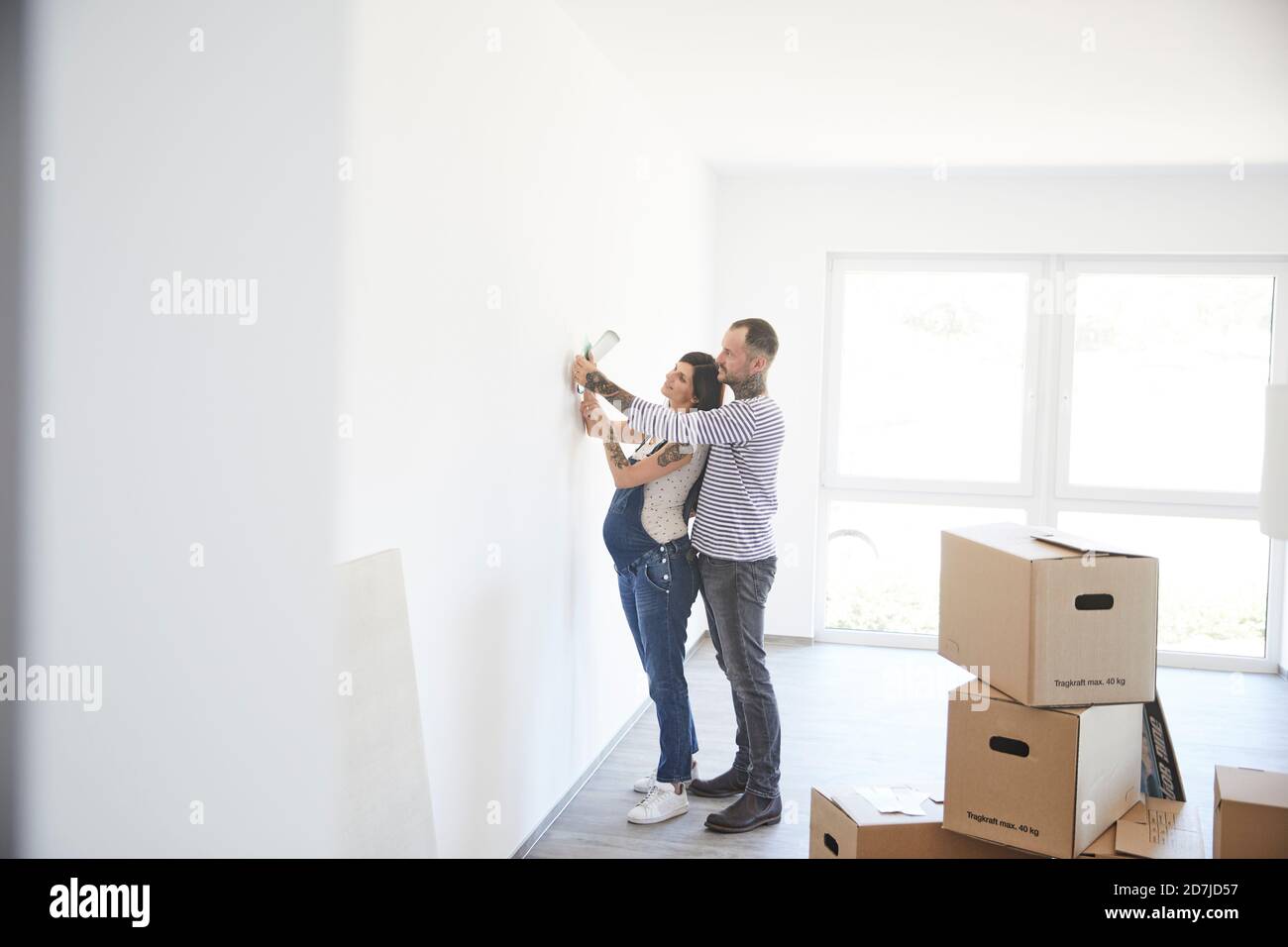 Couple hétérosexuel essayant de la lumière sur le mur à la nouvelle maison Banque D'Images