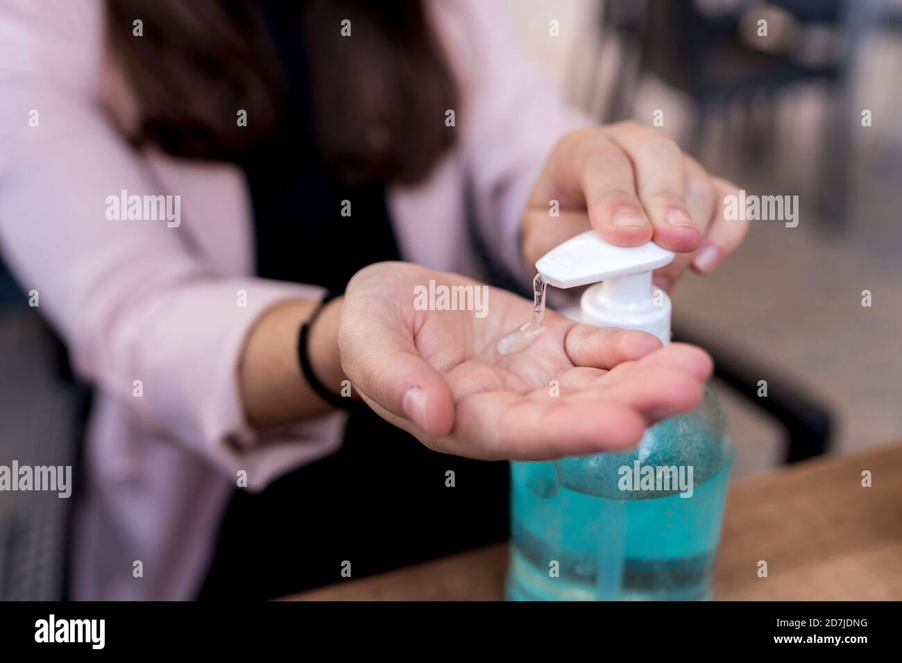 Femme d'affaires utilisant un désinfectant pour les mains dans un café pendant l'épidémie de coronavirus Banque D'Images
