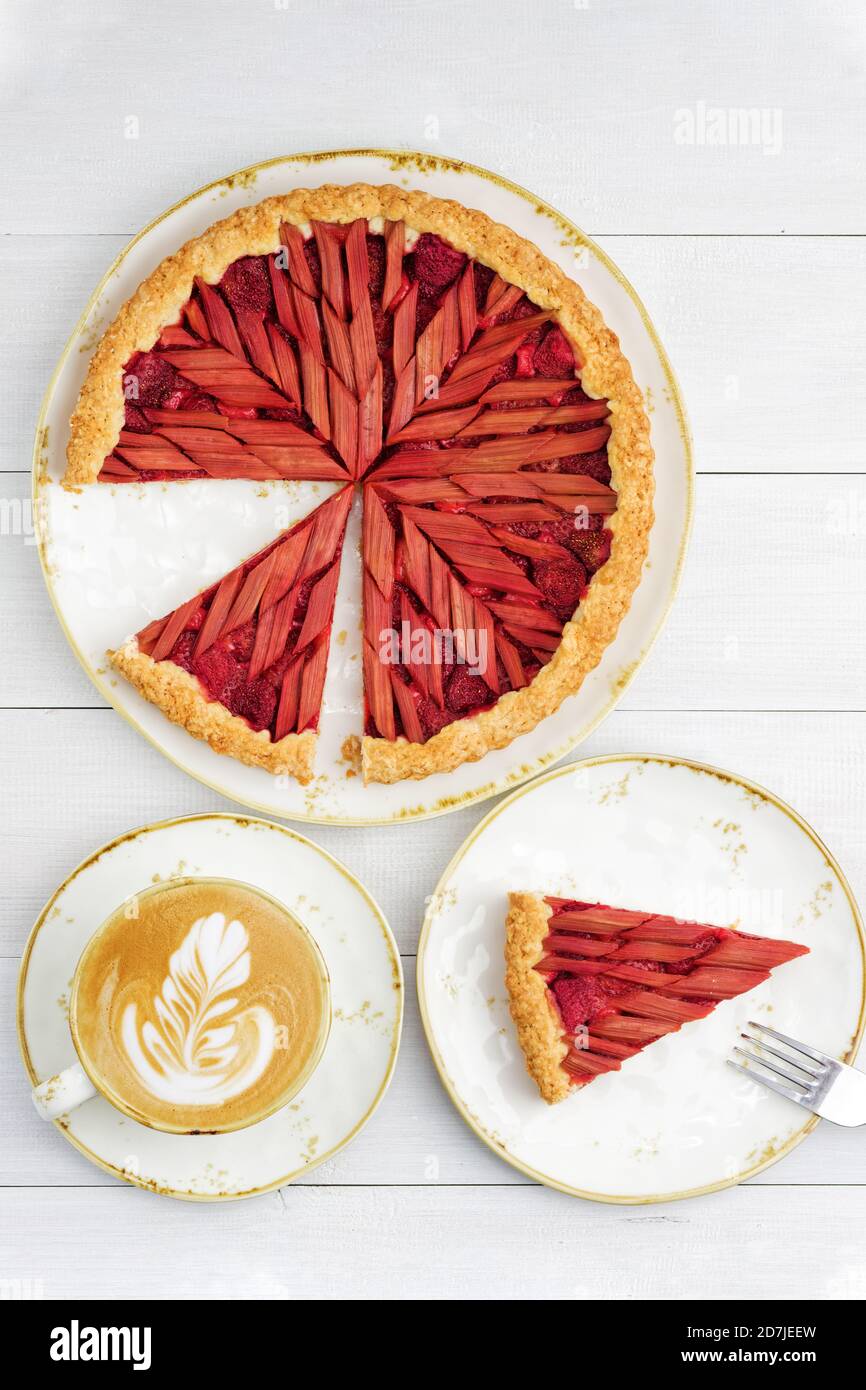 Rhubarbe maison et tarte aux fraises et une tasse de café sur une table en bois blanc. Vue de dessus. Banque D'Images