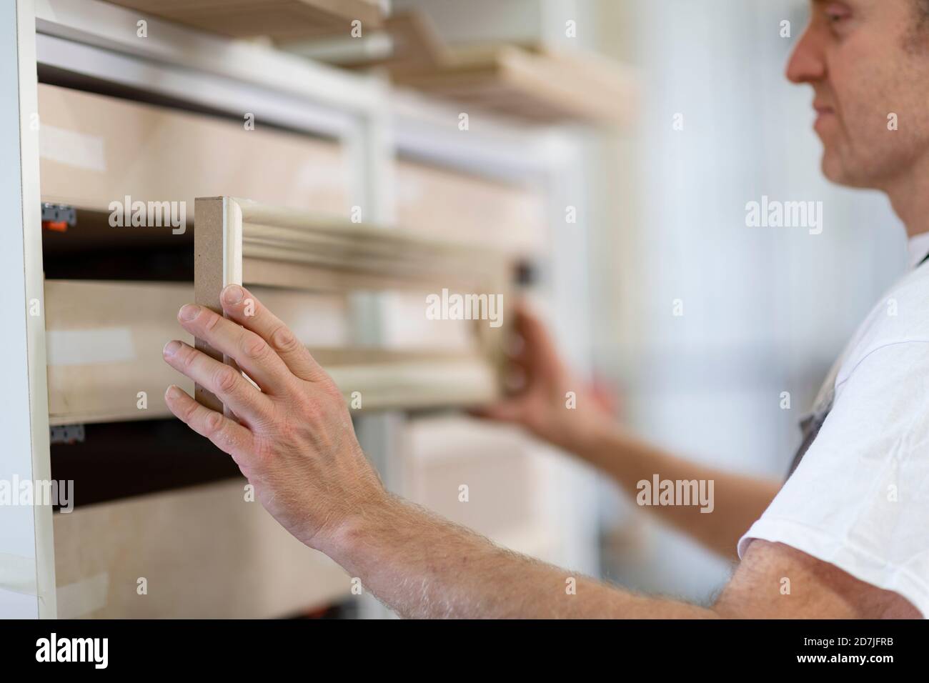 Homme qui pose le cadre dans le tiroir en se tenant à l'atelier Banque D'Images