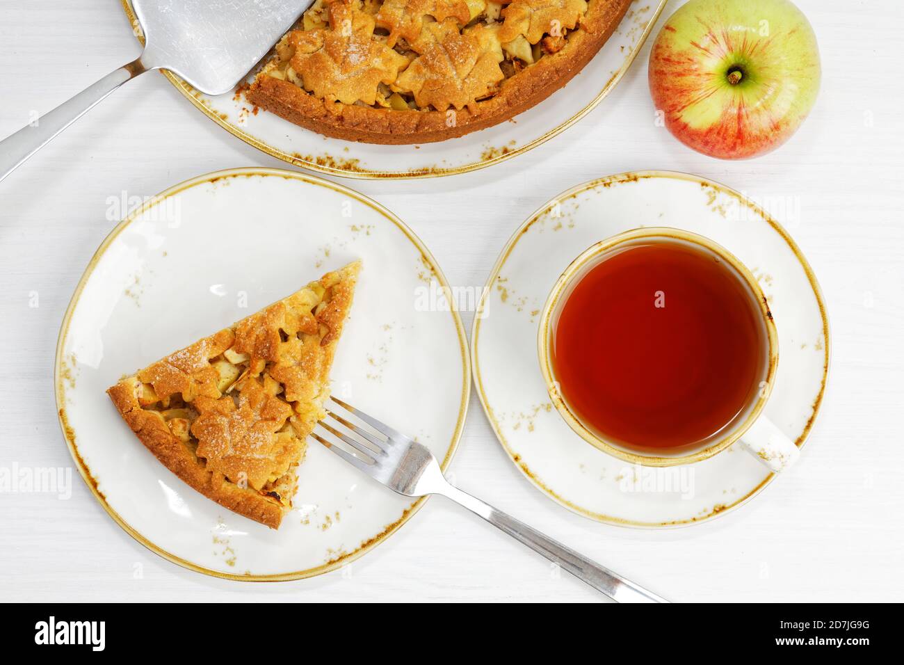 Tarte aux pommes et à la cannelle maison et une tasse de thé sur une table en bois blanc. Vue de dessus. Banque D'Images Tarte aux pommes et à la cannelle maison et une tasse de thé sur une table en bois blanc. Vue de dessus. Banque D'Images