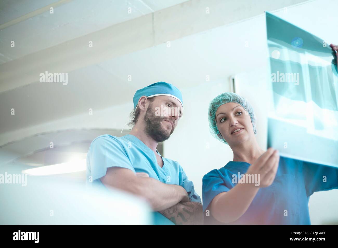 Les médecins masculins et féminins discutent de l'image radiologique médicale dans hôpital Banque D'Images