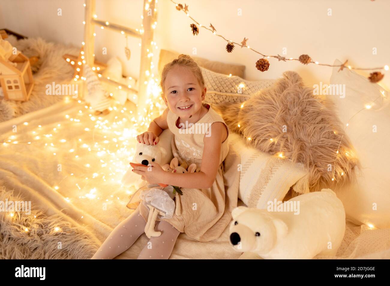 Petite fille mignonne jouant avec un ours en peluche dans la chambre pendant noël Banque D'Images