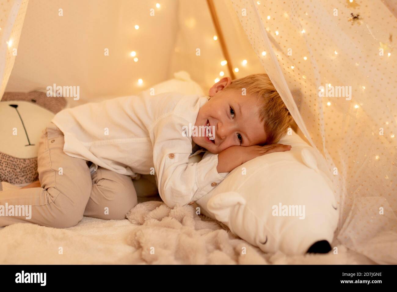 Petit garçon mignon couché sur le lit avec un ours en peluche Banque D'Images