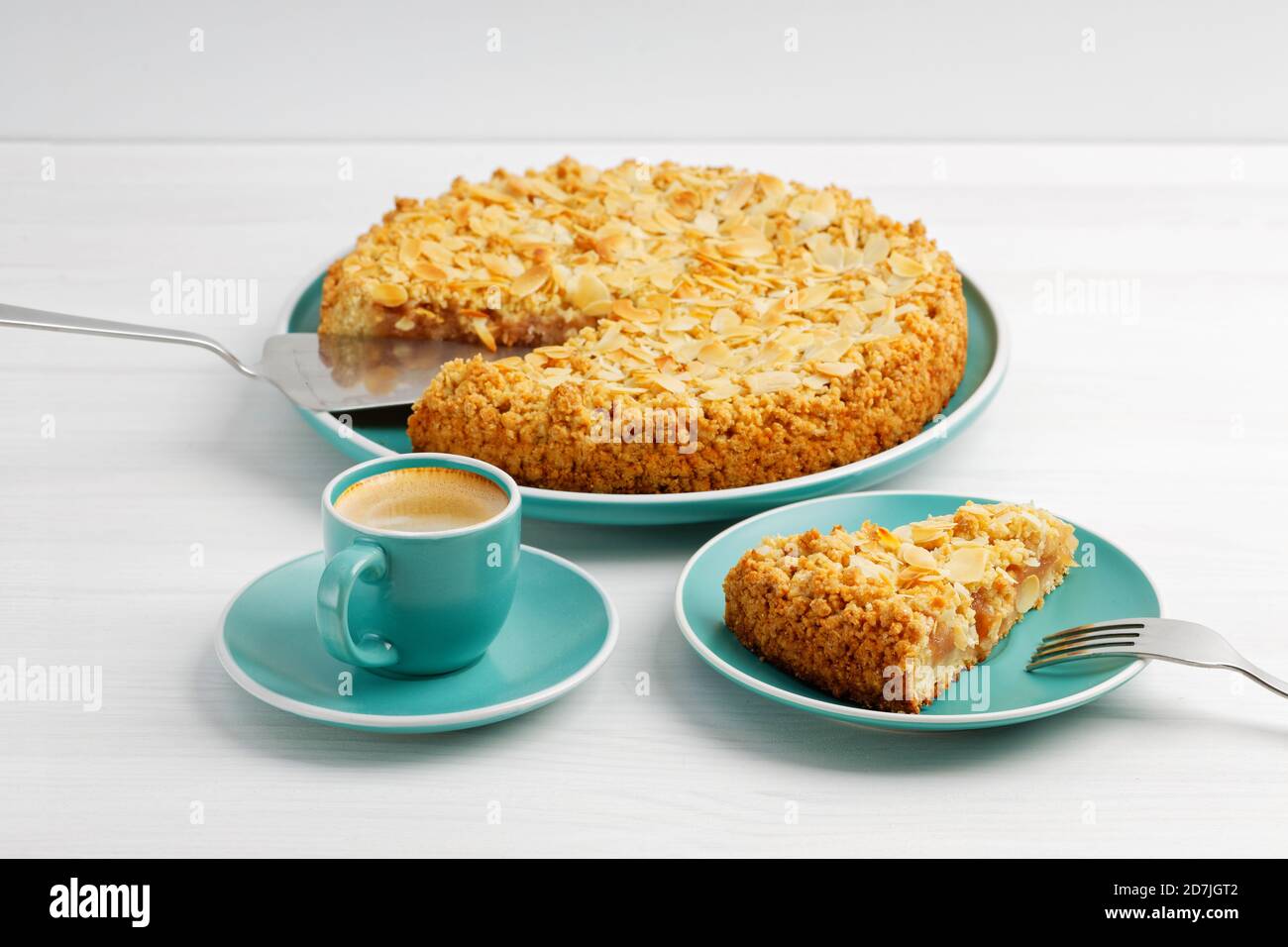Tarte aux pommes aux pétales d'amande et une tasse de café expresso sur table en bois blanc. Banque D'Images Tarte aux pommes aux pétales d'amande et une tasse de café expresso sur table en bois blanc. Banque D'Images