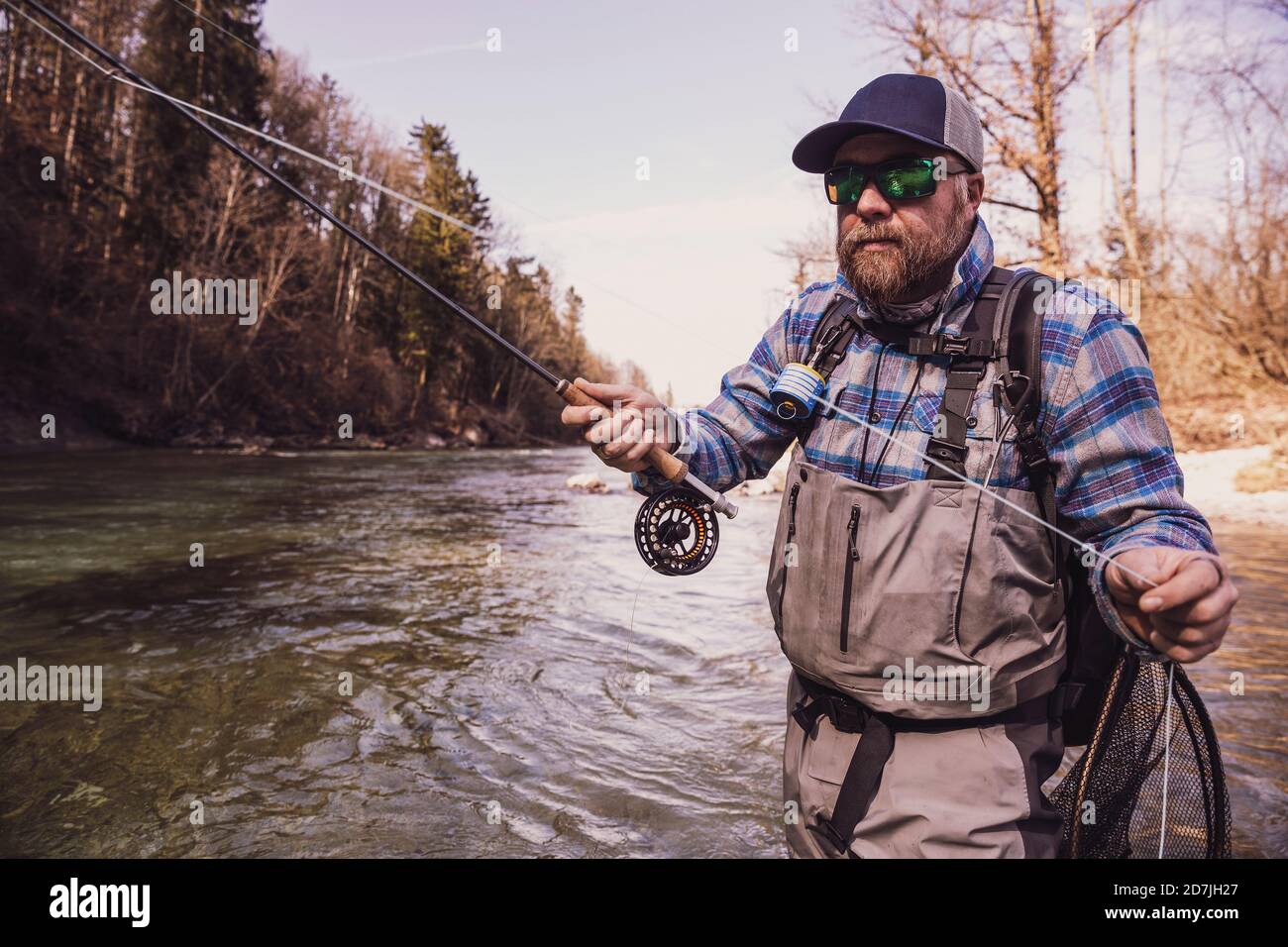 Homme attrapant du poisson de la rivière par beau temps Banque D'Images