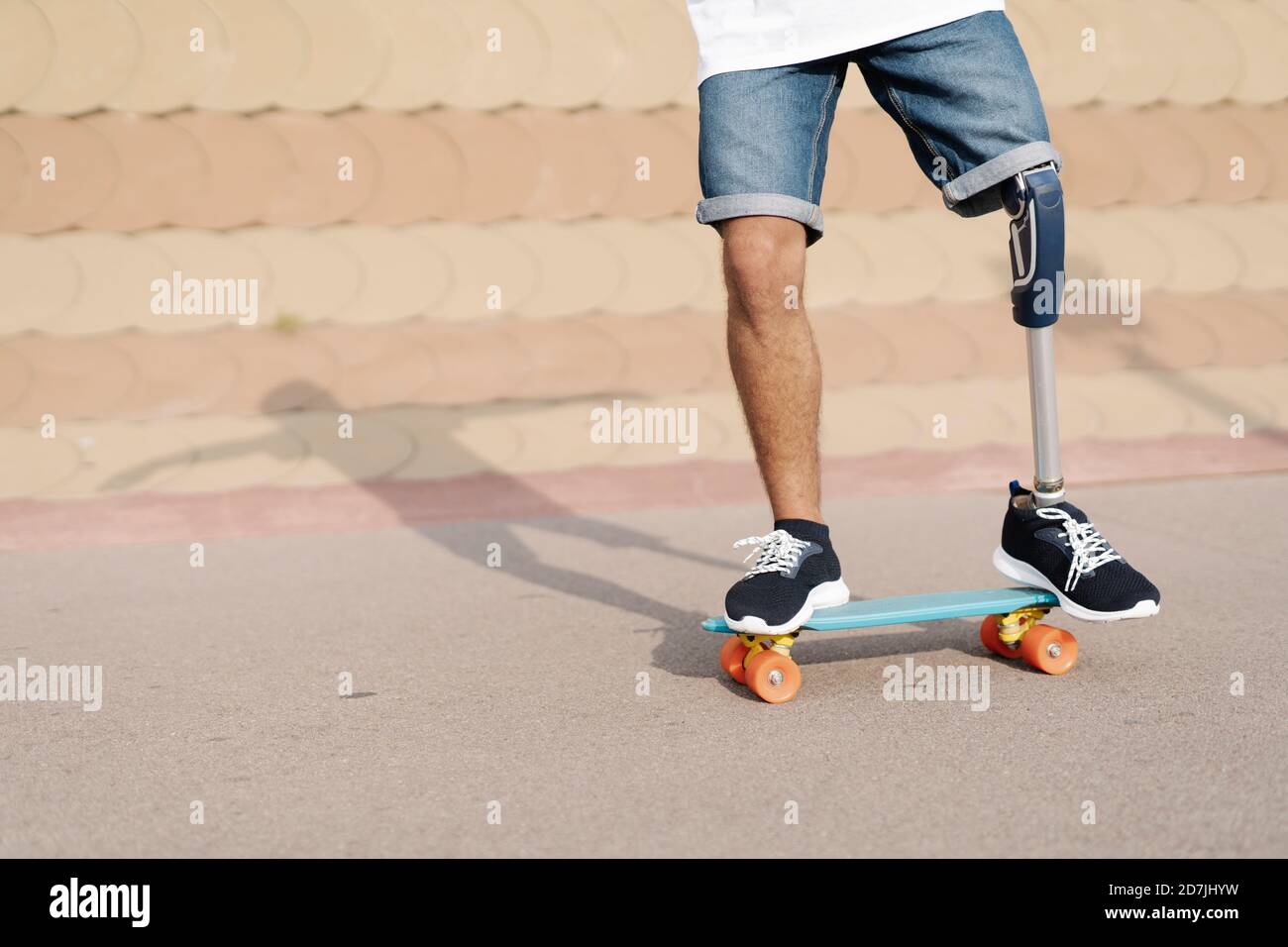 Jeune homme ayant une déficience physique debout sur un skateboard dans un sport cour Banque D'Images
