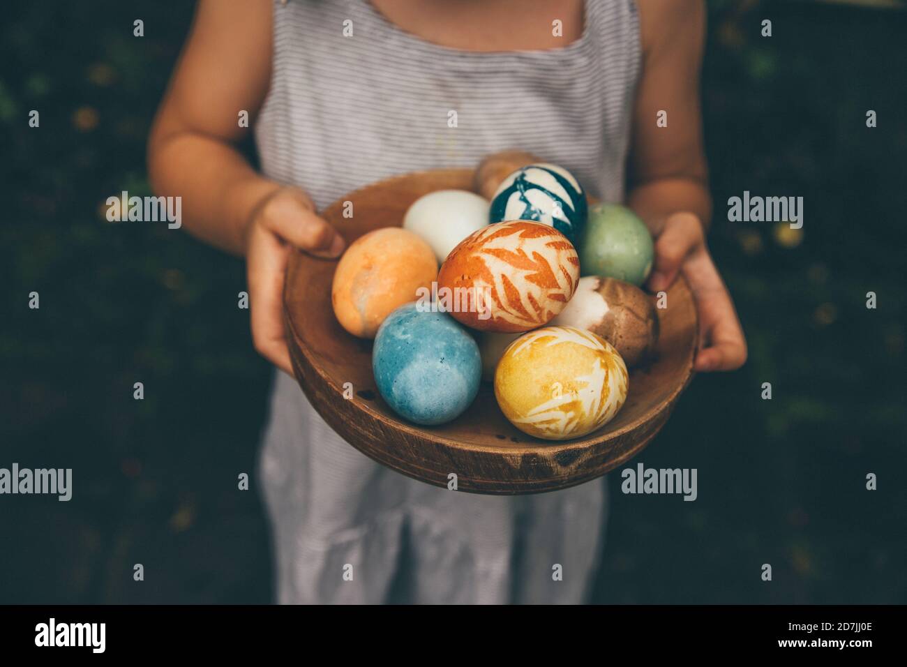 Petite fille tenant un bol d'œufs de Pâques colorés de couleur biologique Banque D'Images