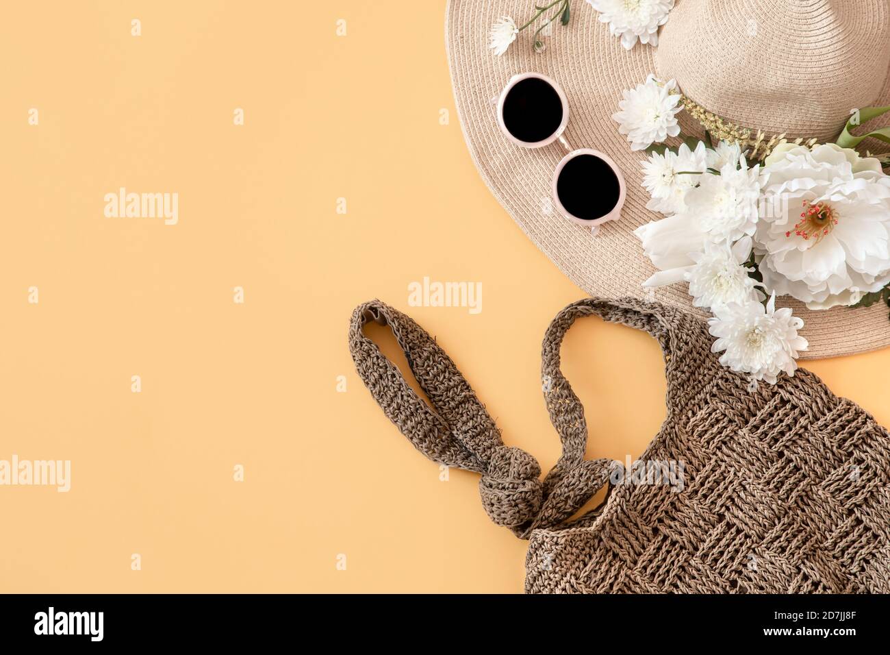 Arrière-plan été élégant avec accessoires été.chapeau en osier, sac, et lunettes. Articles de mode et de voyage d'été. Fond orange pastel Uni . Somme Banque D'Images