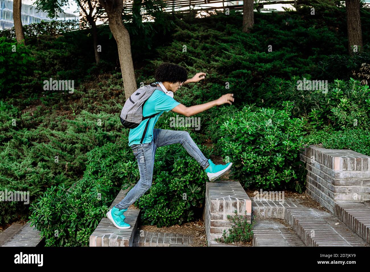Un jeune homme sautant d'un banc à l'autre en public stationnement Banque D'Images