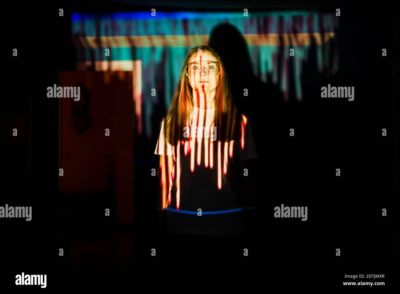 Femme adulte de taille moyenne debout dans le reflet de la lumière à la maison pendant pandémie Banque D'Images