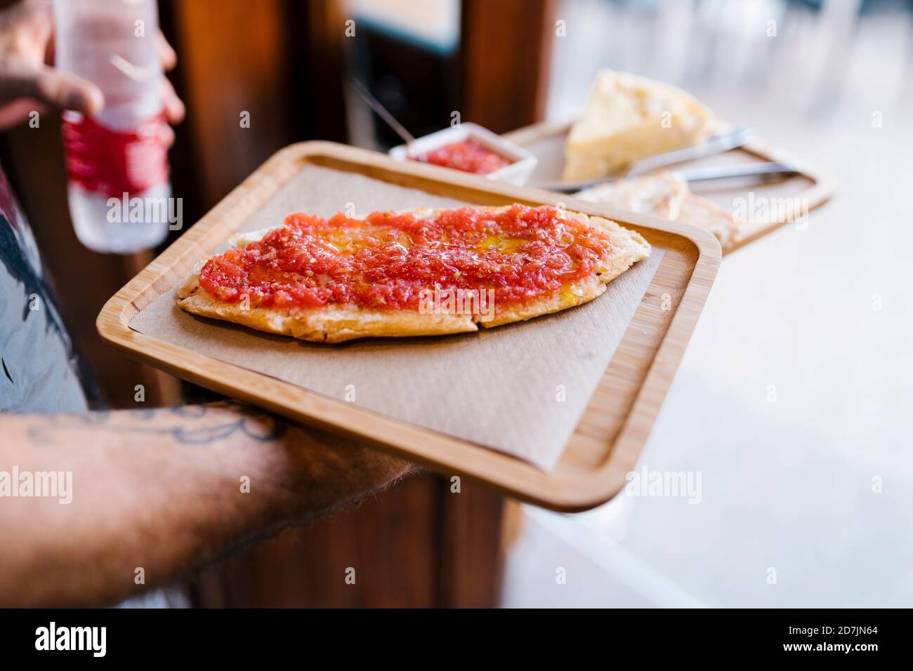 Un garçon sert un sandwich aux tomates dans un café Banque D'Images