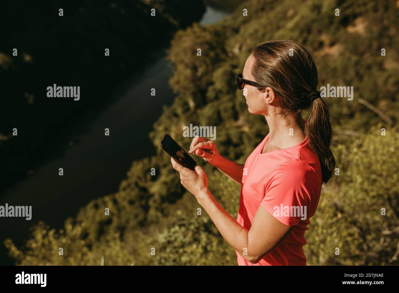 Femme utilisant un téléphone portable en montagne à Sierra de Hornachuelos, Cordoue, Espagne Banque D'Images