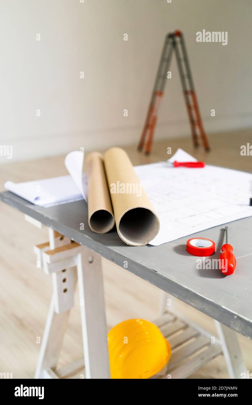 Des plans roulés couchés sur le bureau dans le studio d'architectes Banque D'Images