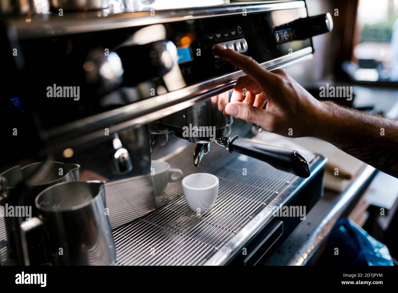 Un barista masculin prépare un café au café Banque D'Images