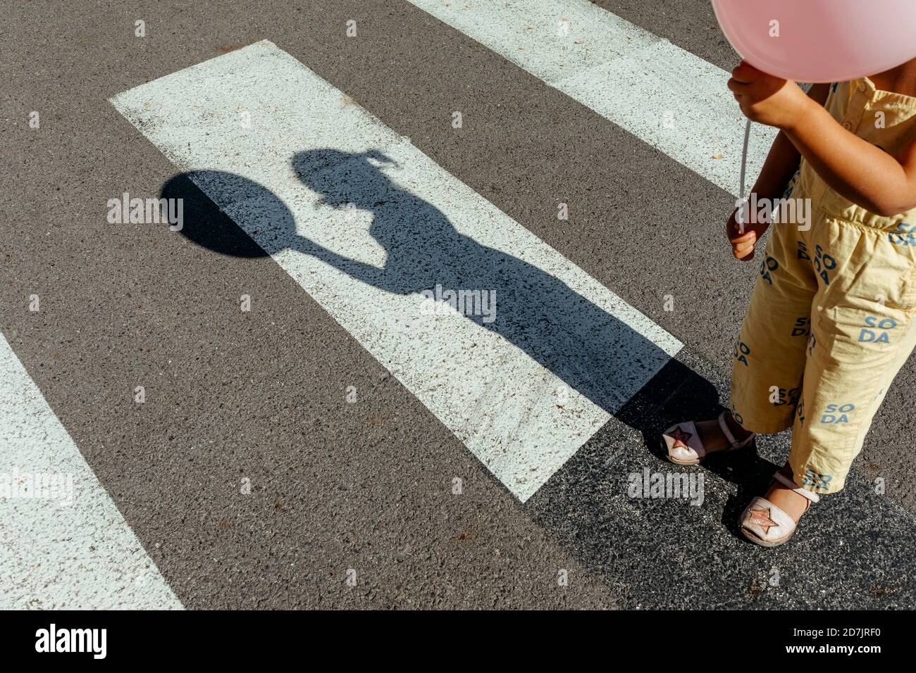 Jeune fille tenant un ballon tout en se tenant à la promenade transversale  dans la ville Photo Stock - Alamy