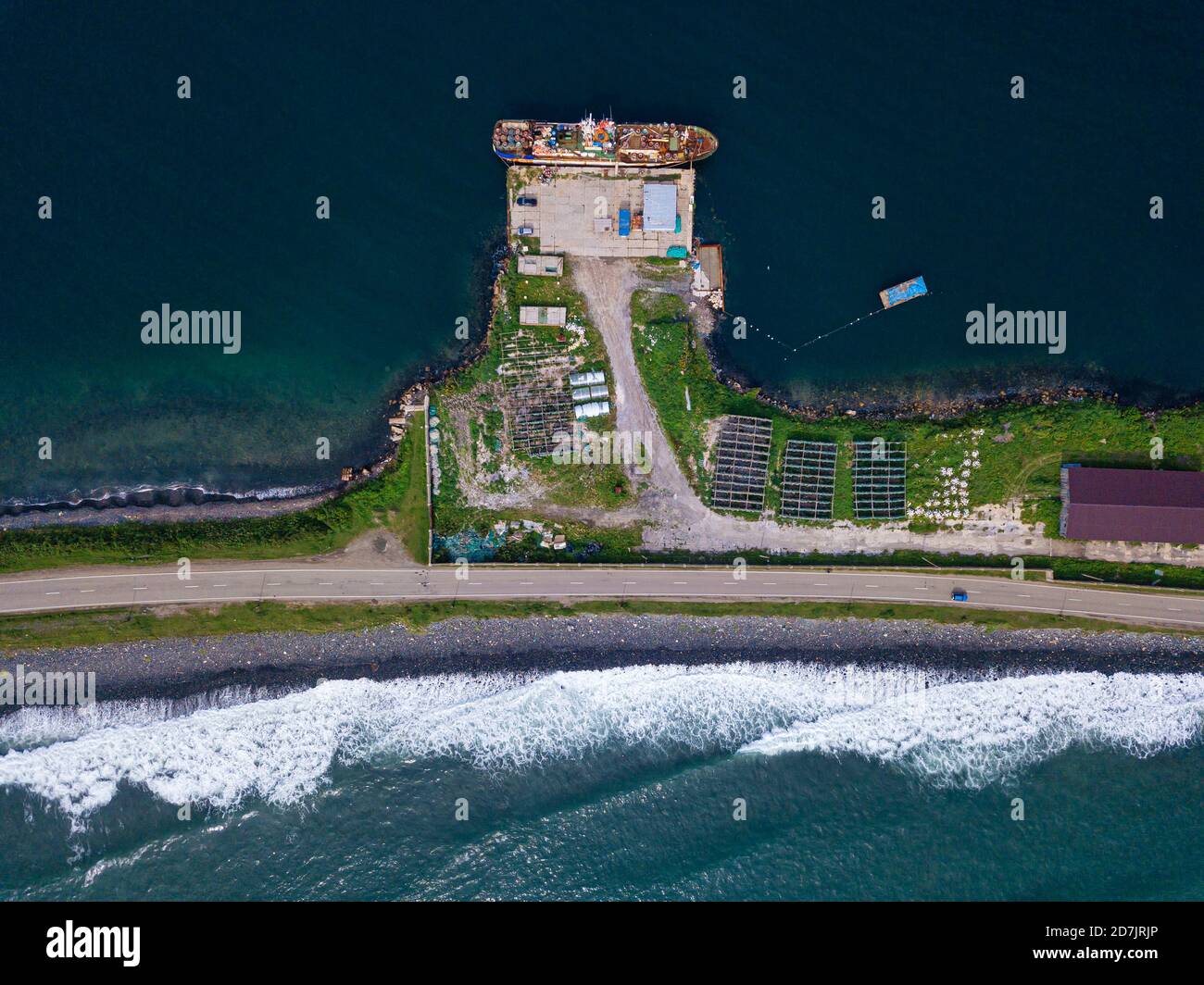 Russie, Primorsky Krai, Zarobino, vue aérienne du village côtier et route s'étendant le long d'une étroite bande de terre Banque D'Images