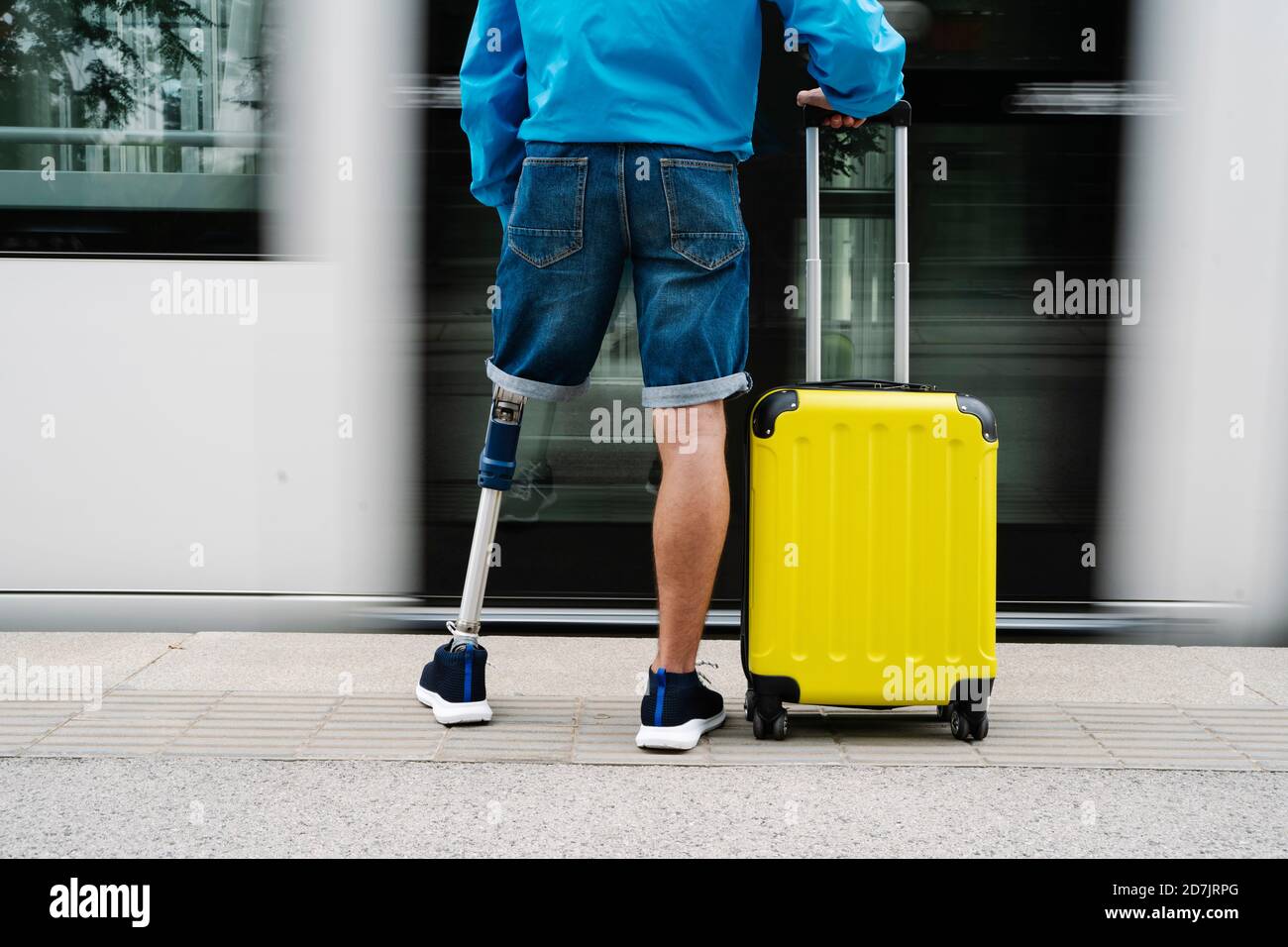 Jeune homme avec un membre et un pied artificiels debout près des bagages à  la gare Photo Stock - Alamy