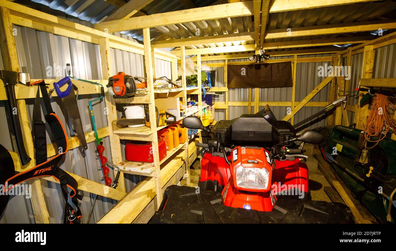 Red Polaris Sportsman 570 modèle ATV 2018 à l'intérieur d'un hangar à outils avec inventaire d'autres équipements , Finlande Banque D'Images