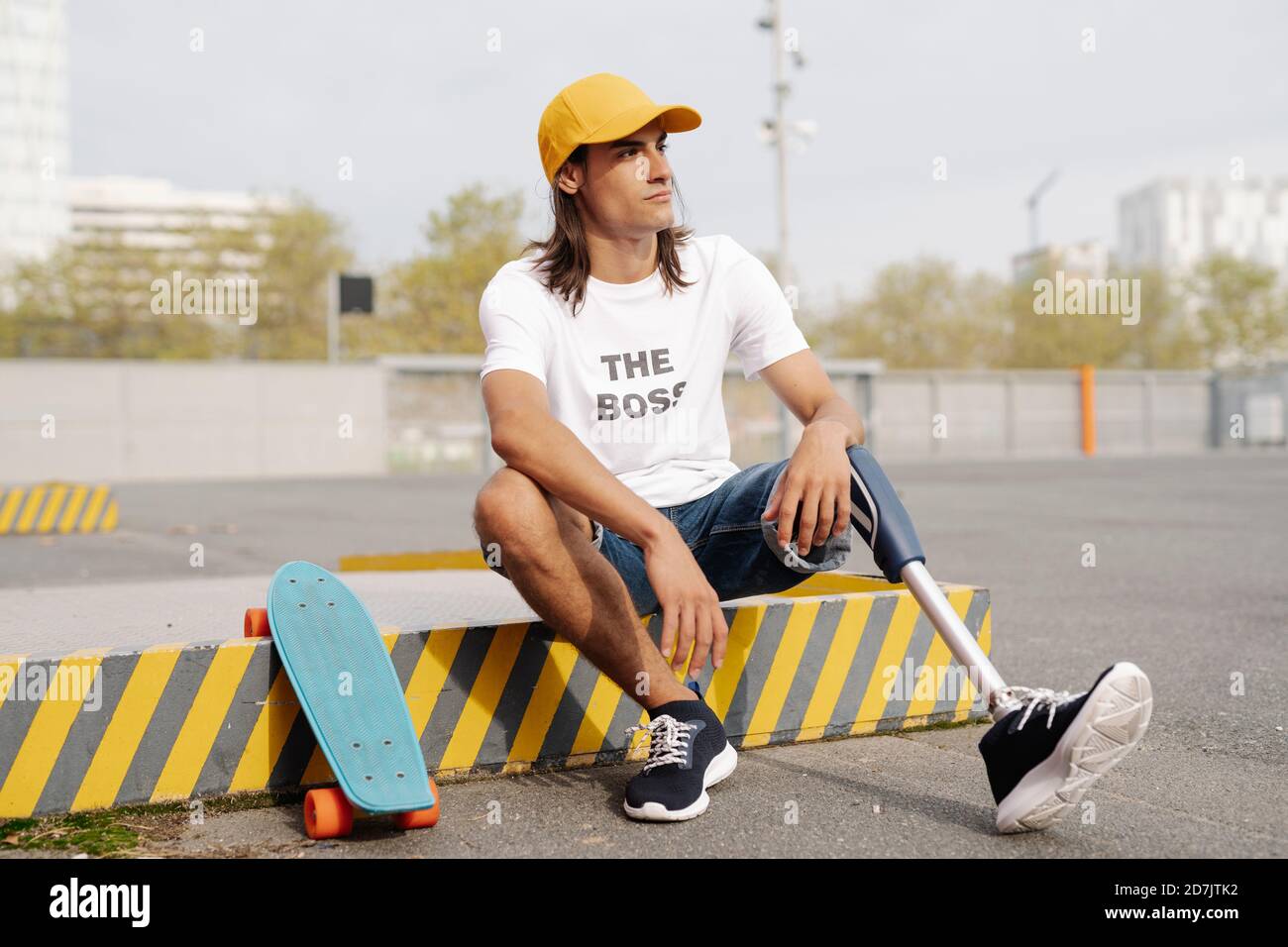 Désactiver l'homme assis à bord d'un skateboard sur la route en ville Banque D'Images