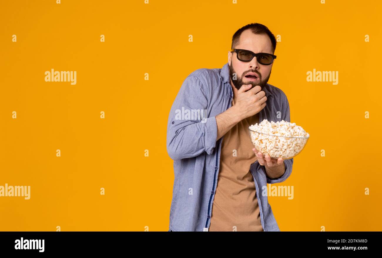 Un jeune homme choqué dans des vêtements décontractés lunettes 3d isolées sur fond jaune. Les gens sincères émotions dans le concept de style de vie de cinéma. Regarder Banque D'Images