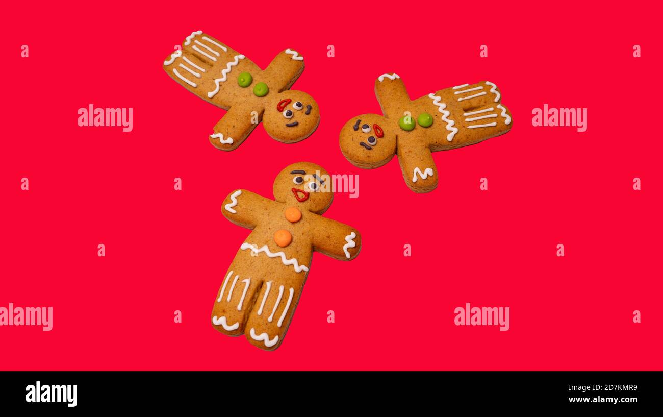 Gros plan des hommes de pain d'épice sur fond rouge. Des pains d'épice décoratifs de fête pour l'ambiance de Noël avec de l'espace pour votre texte. Concept de cookie classique Banque D'Images