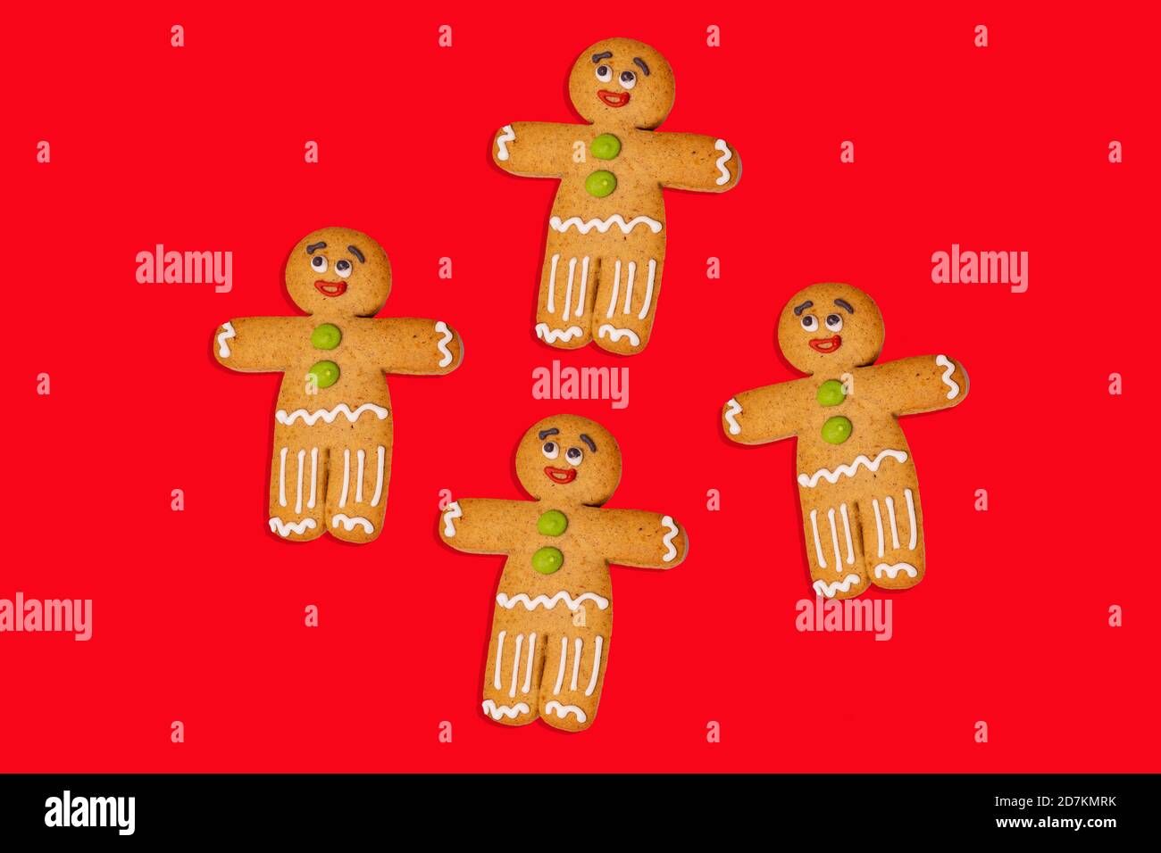 Gros plan des hommes de pain d'épice sur fond rouge. Des pains d'épice décoratifs de fête pour l'ambiance de Noël avec de l'espace pour votre texte. Concept de cookie classique Banque D'Images