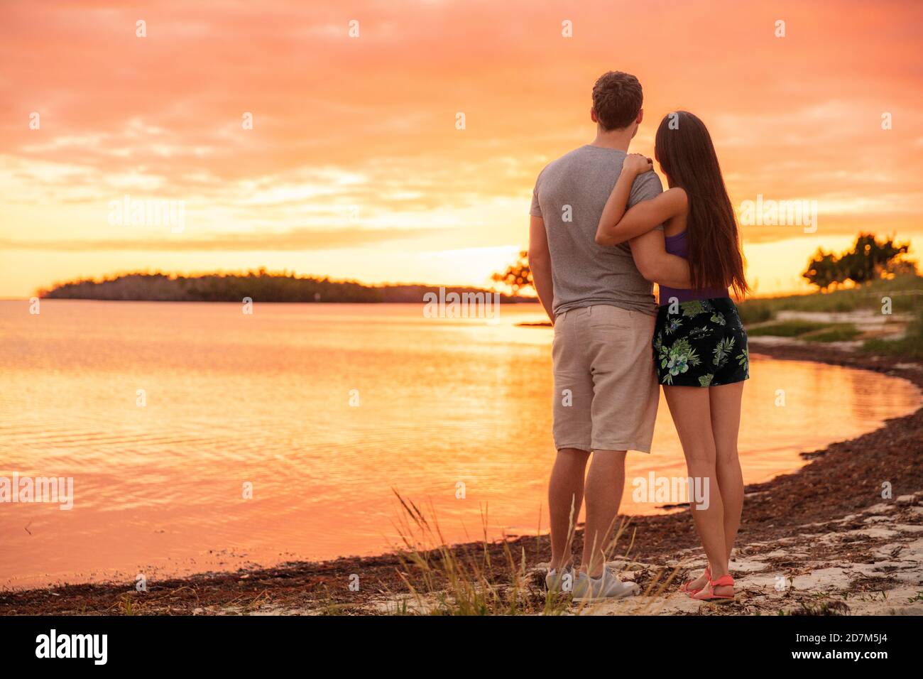 Couple amoureux appréciant le coucher de soleil sur la plage Photo Stock -  Alamy