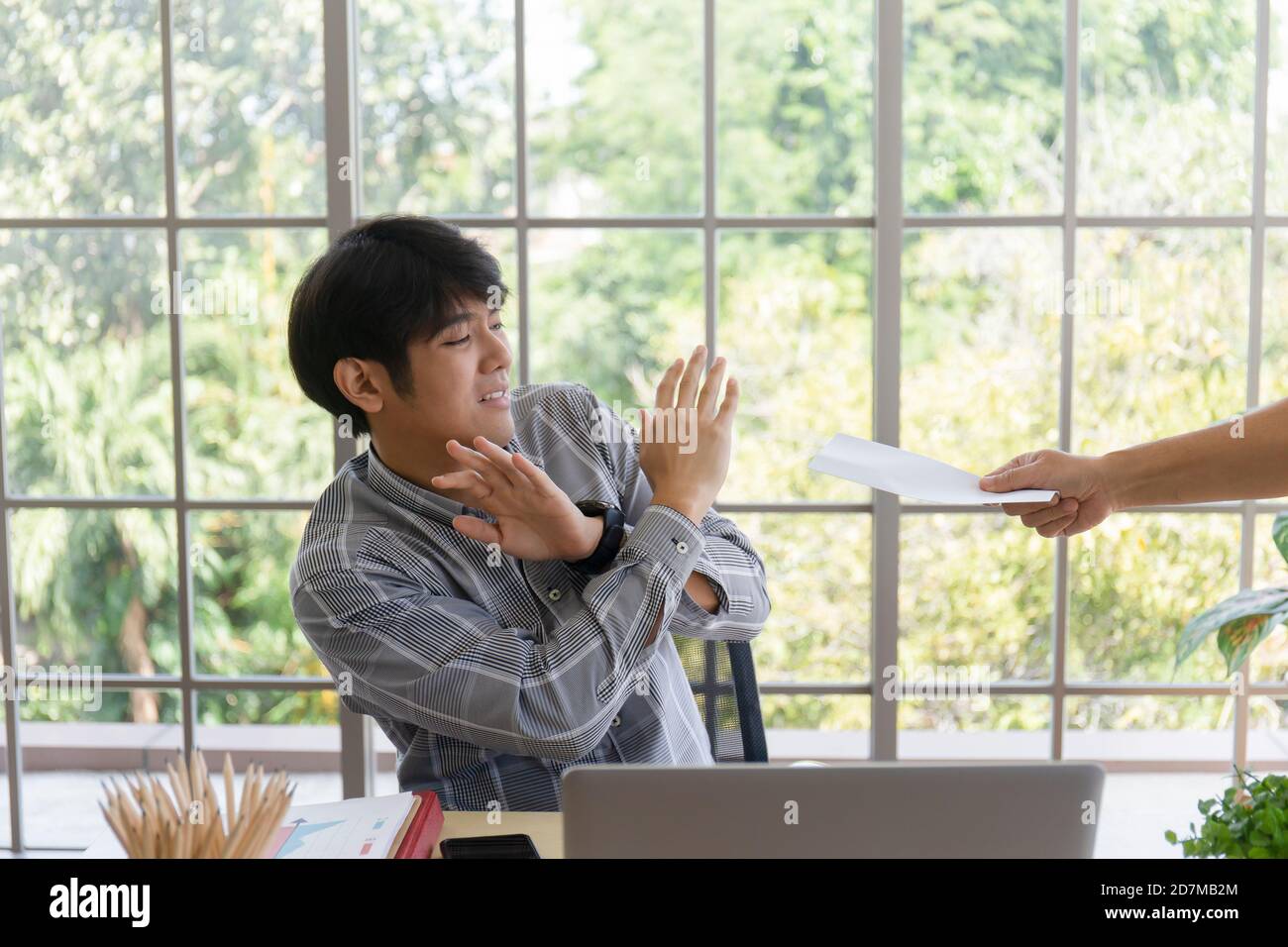 Une main qui livre des documents à un homme asiatique en difficulté avec de mauvaises nouvelles: Un entrepreneur désespéré est mis à pied, se cache pleurer, déçu par la faillite Banque D'Images