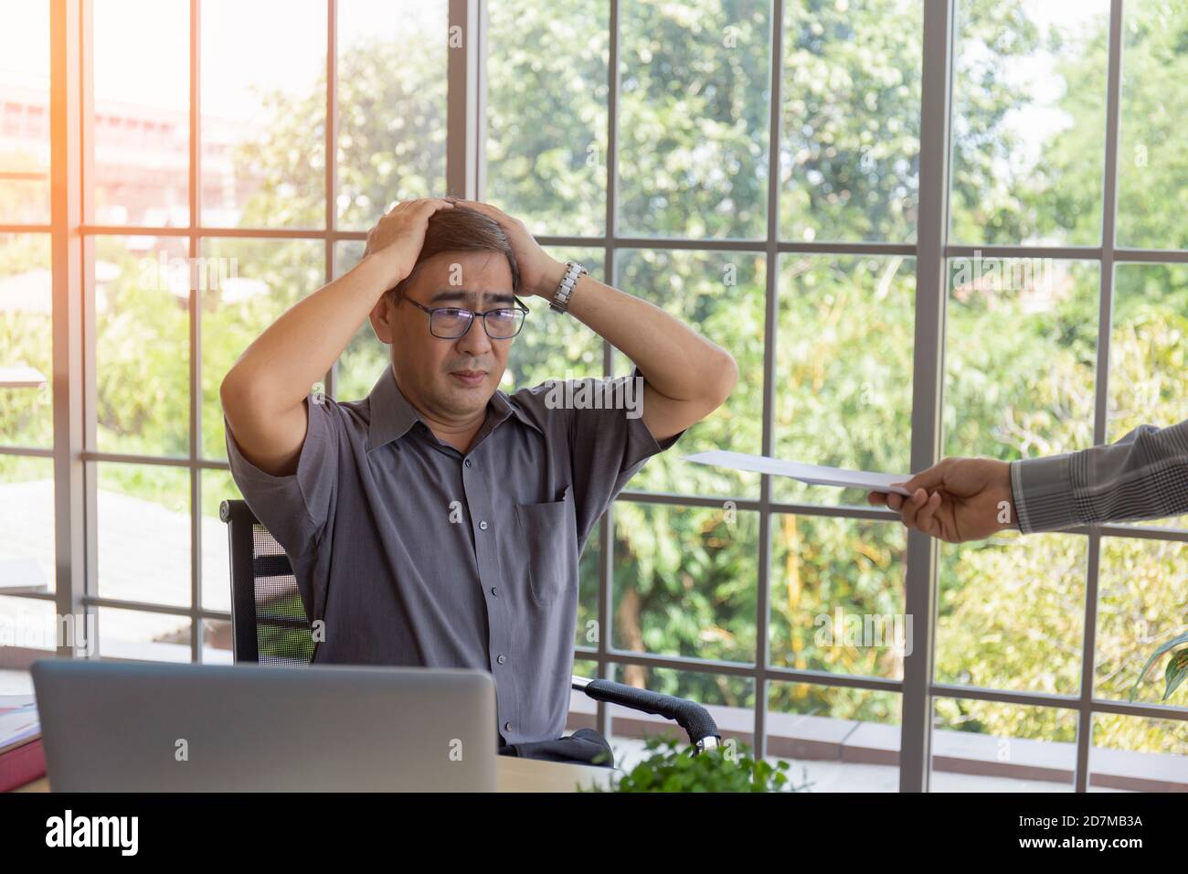 La main qui livre des documents à un homme asiatique en difficulté d'âge moyen avec les mauvaises nouvelles: Les entrepreneurs désespérés sont mis à pied, se cachent, pleurer, déçus Banque D'Images