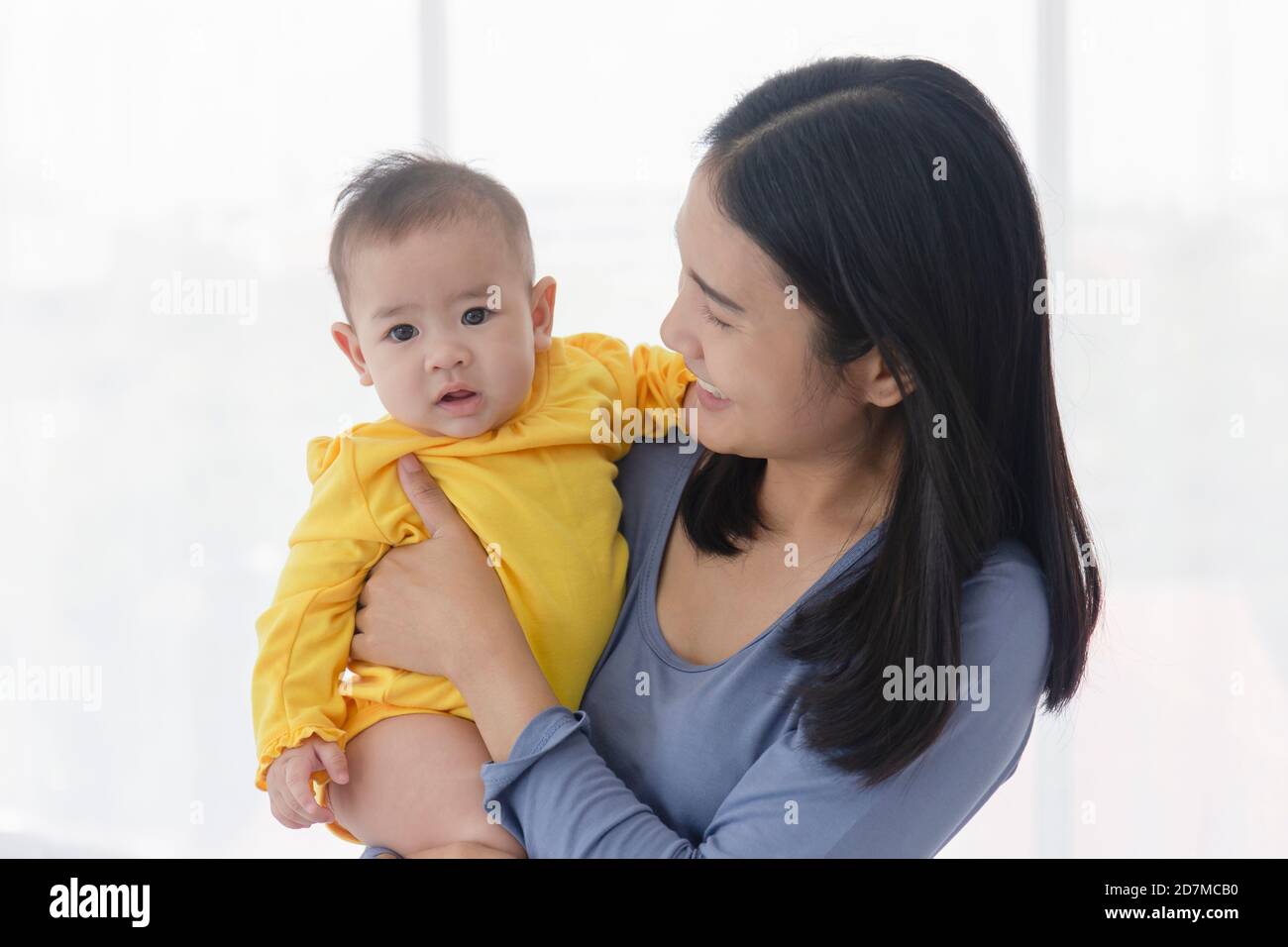 Une mère asiatique porte son bébé avec amour et soin. Banque D'Images