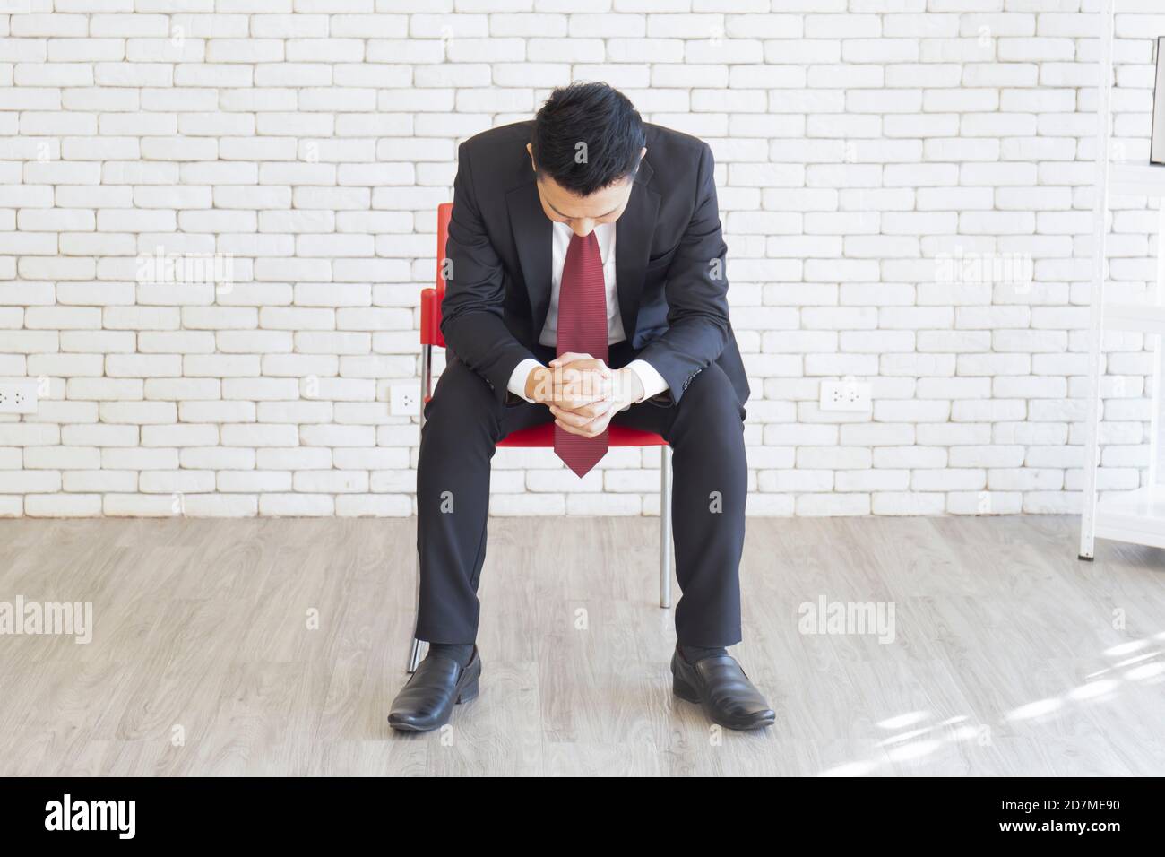 Un homme asiatique portant un costume, assis, les mains calment votre esprit sur la chaise Banque D'Images
