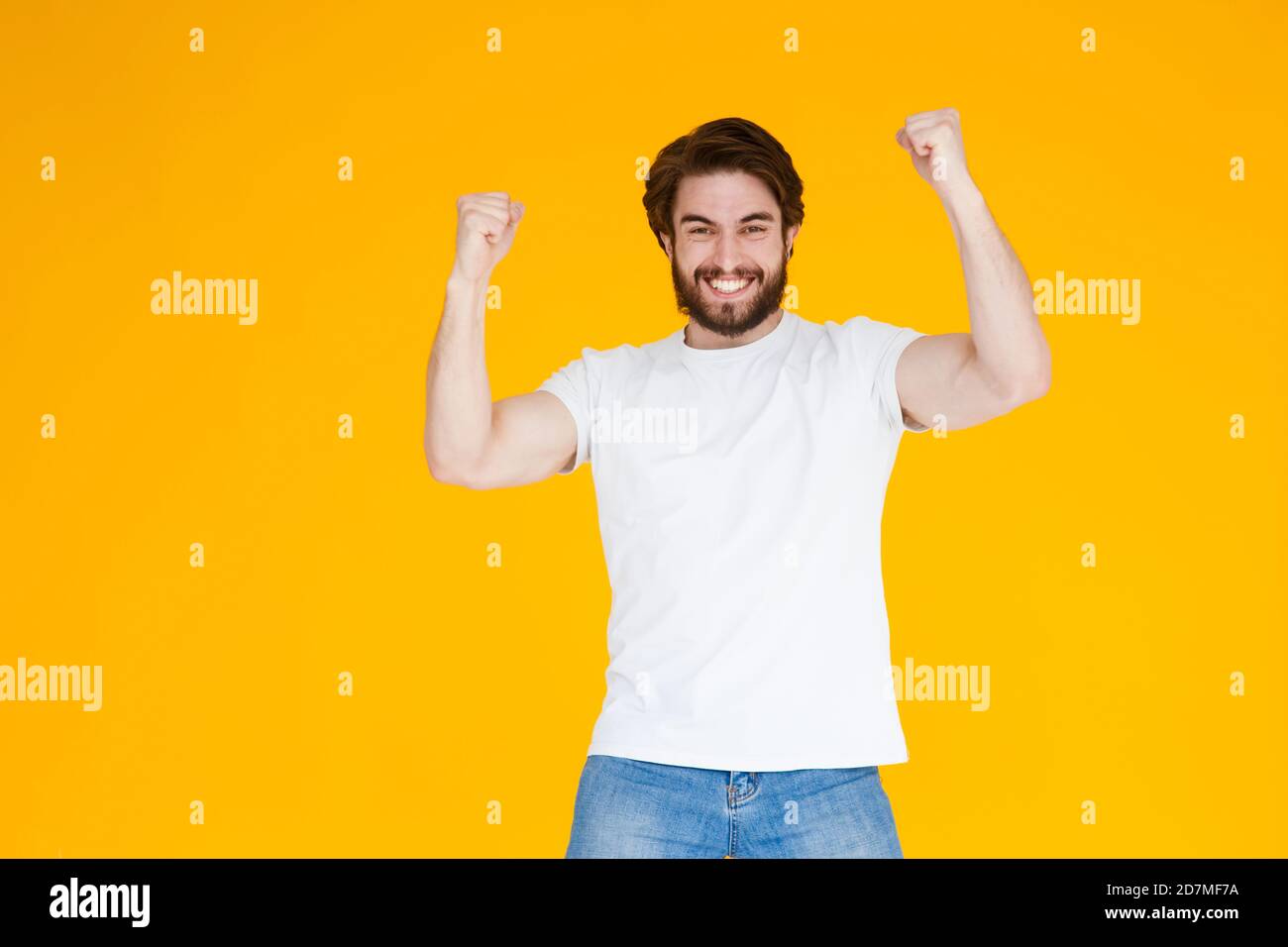 Portrait d'un homme barbu joyeux célébrant le succès isolé arrière-plan jaune Banque D'Images