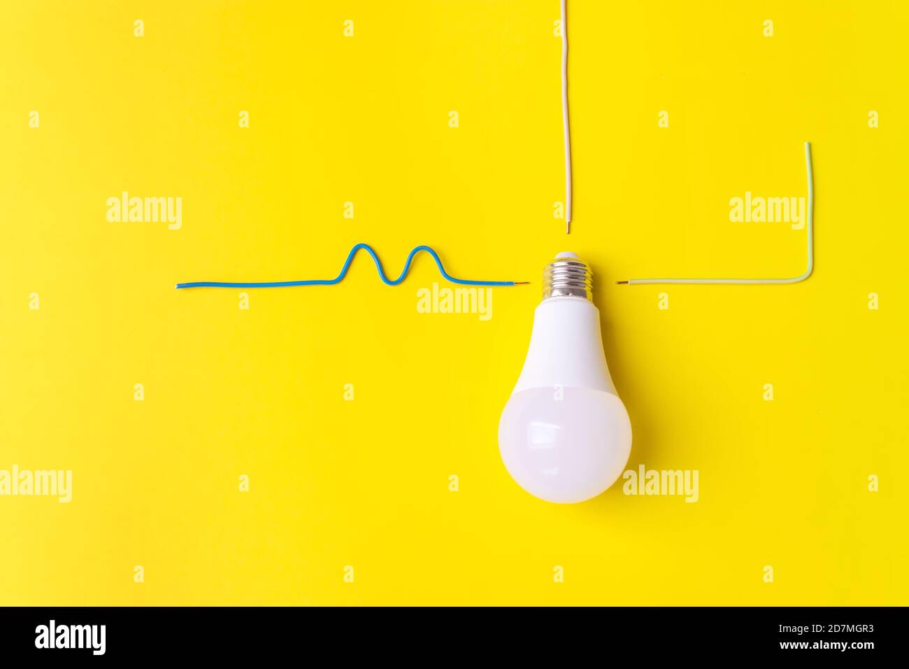 Ampoule blanche sur fond jaune avec fils phase, zéro, masse. Concept de connexion Banque D'Images
