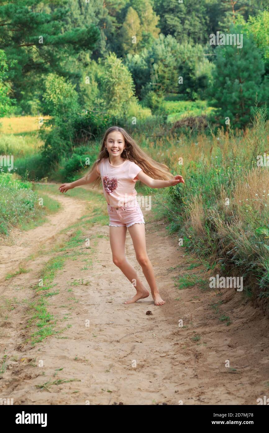 Belle jeune fille danse dehors au coucher du soleil d'été Banque D'Images