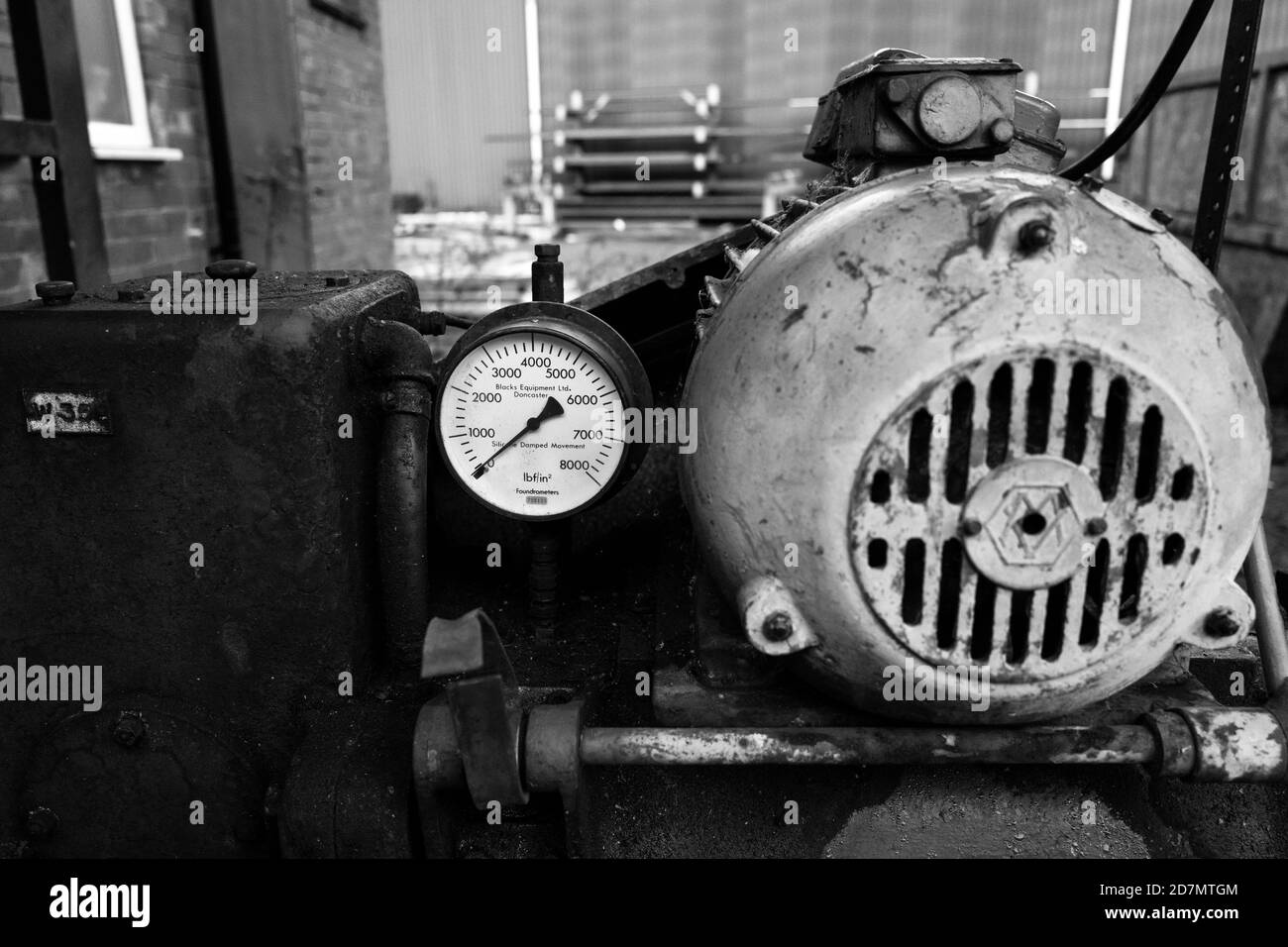 Ancien moteur électrique 3 phases entraînant un manomètre de compresseur à pression nulle. Banque D'Images