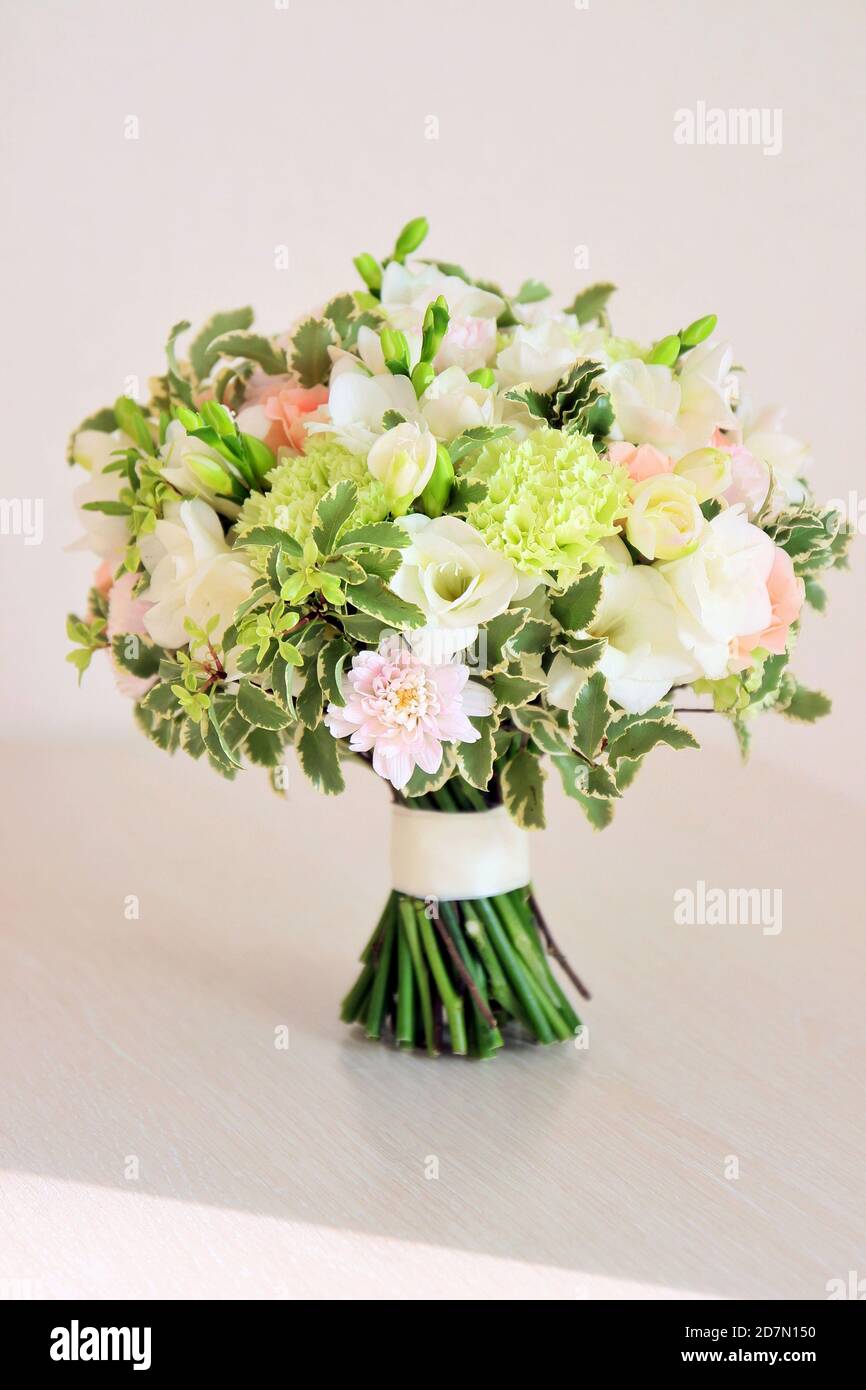 Bouquet de couleurs menthe et pêche sur table en bois. Freesia blanc,  dianthus vert, roses de pêche, chrysanthème clair et verts frais Photo  Stock - Alamy