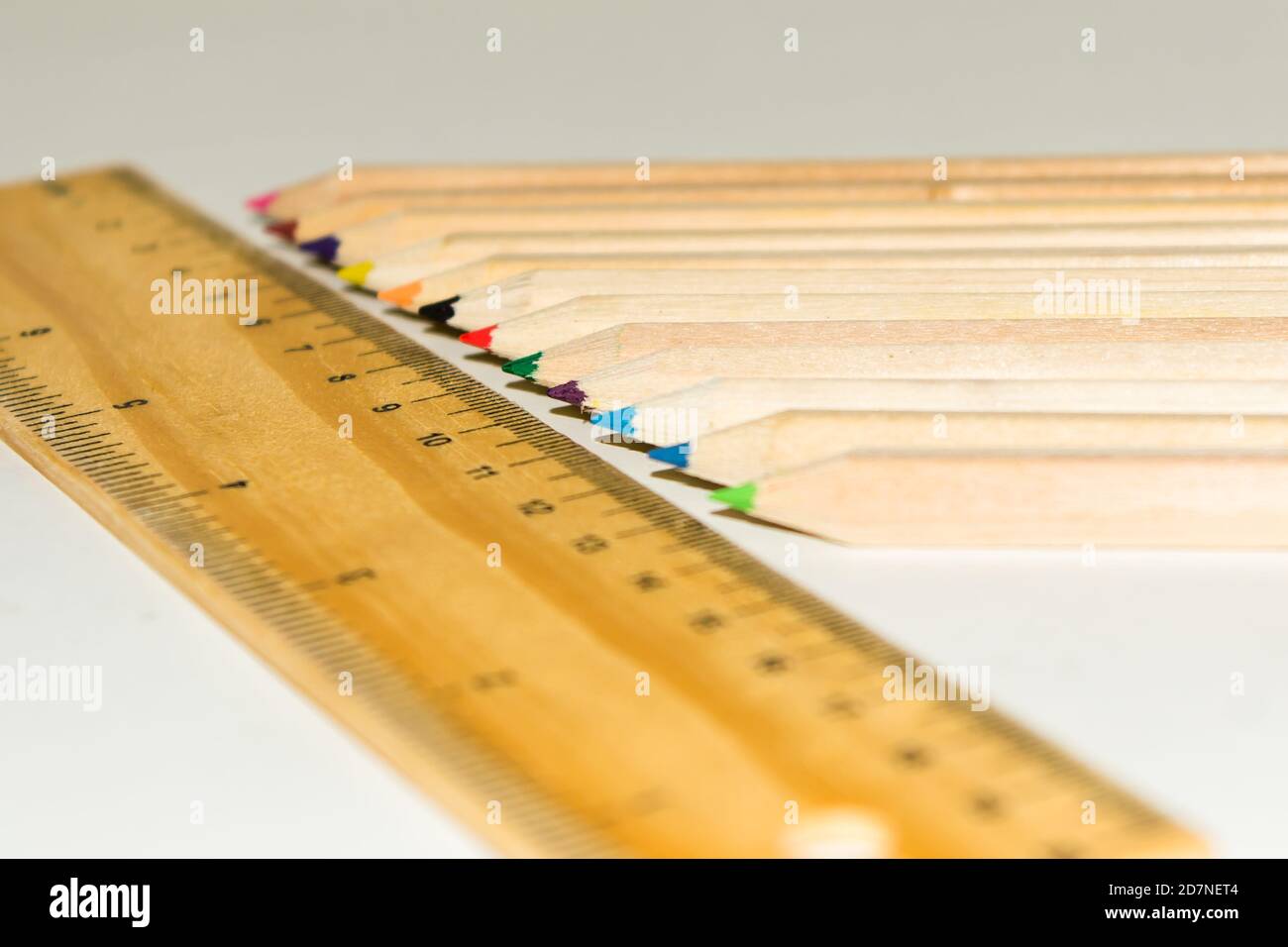 Couleur crayon en forme d'hexagone et règle en bois sur fond blanc. Banque D'Images