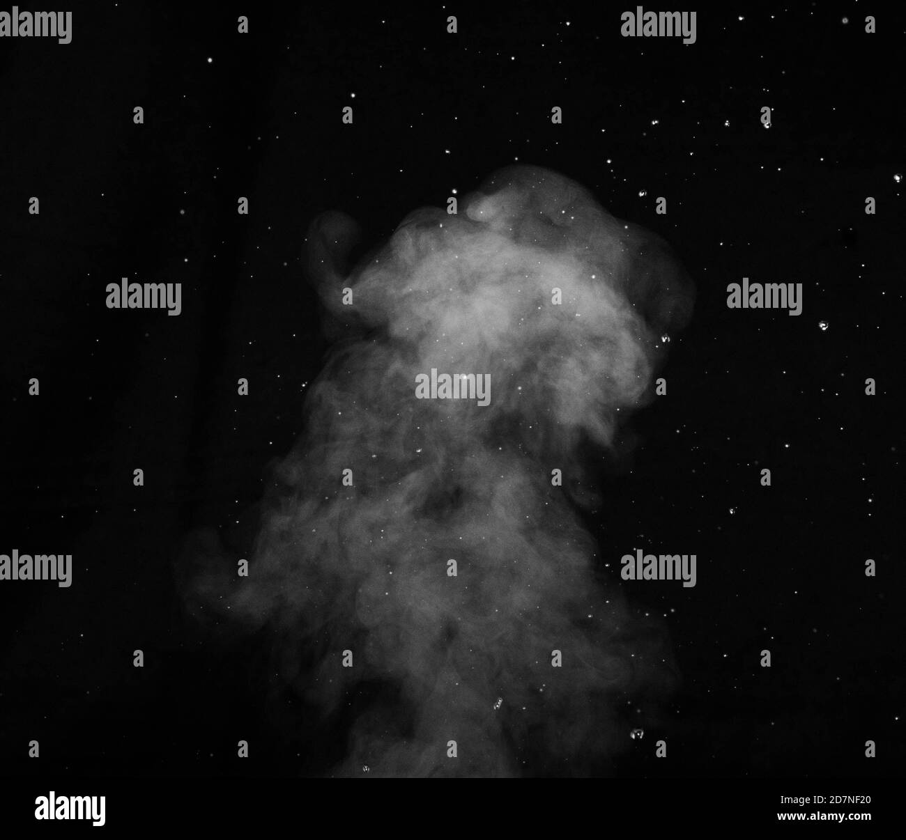 Vapeur blanche pulvérisée du saturateur d'air. Fragments de fumée sur fond noir Banque D'Images